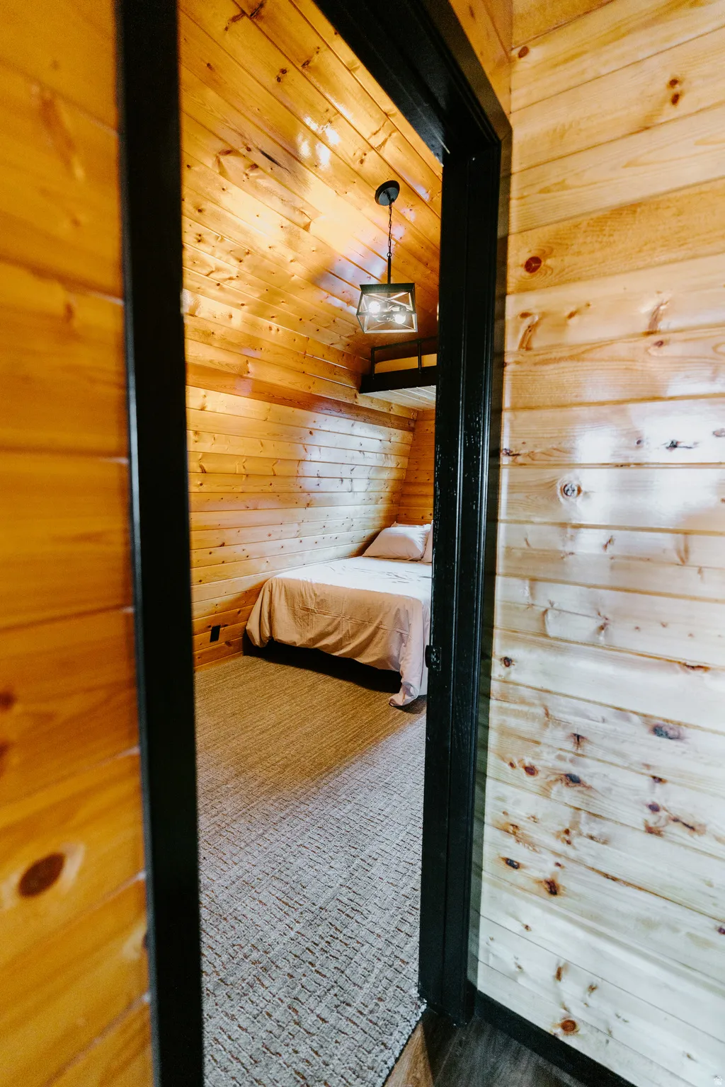 Unfurnished bedroom with wood walls and dark colored carpet