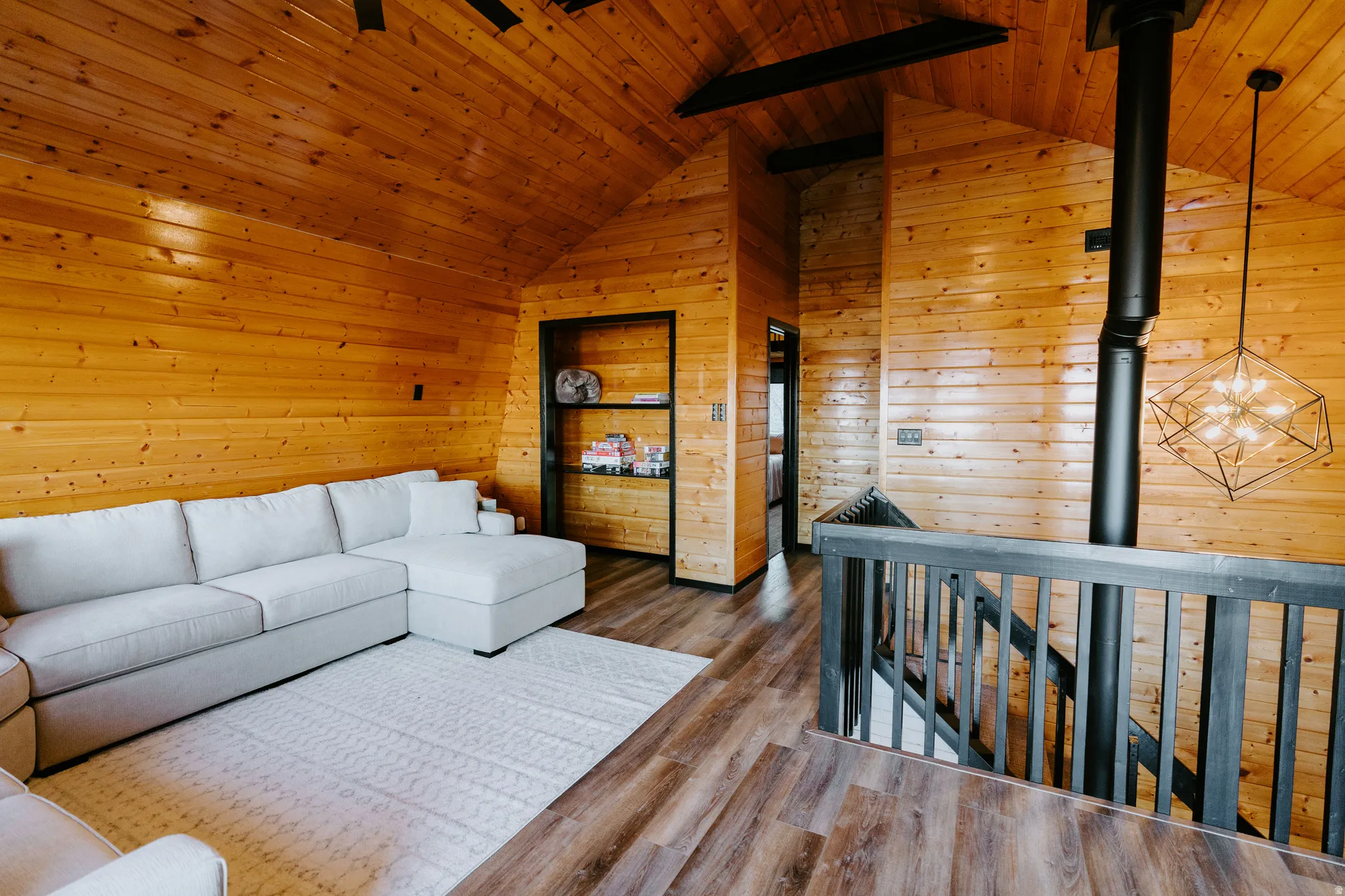 Living room featuring wooden walls, a wooden ceiling with exposed beams, and wood finished floors