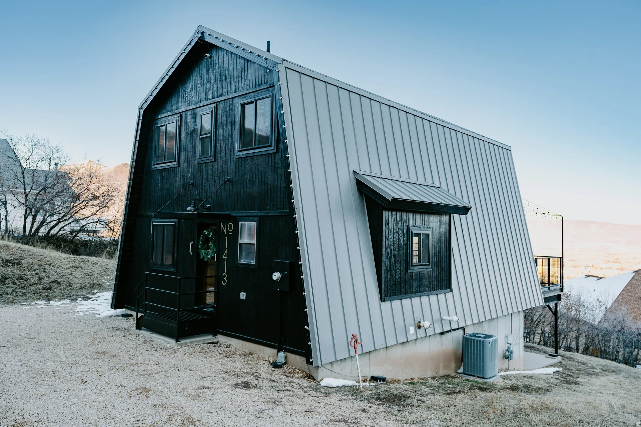 View of home's exterior with a metal roof and a gambrel roof