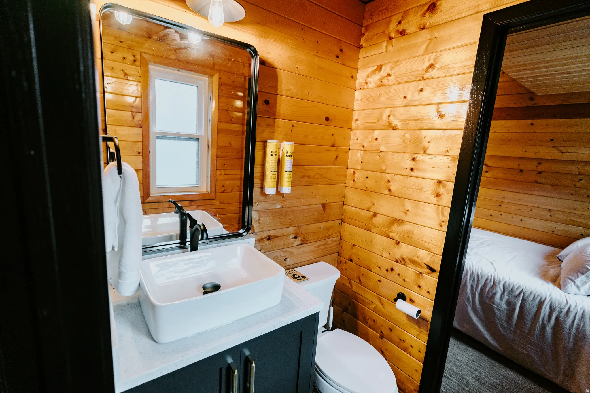 Bathroom with wooden walls, vanity, and ensuite bathroom