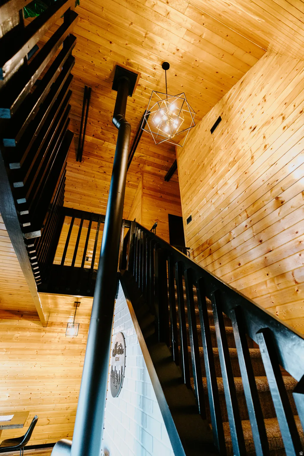 Stairs with wood walls, wood ceiling, and a wood stove