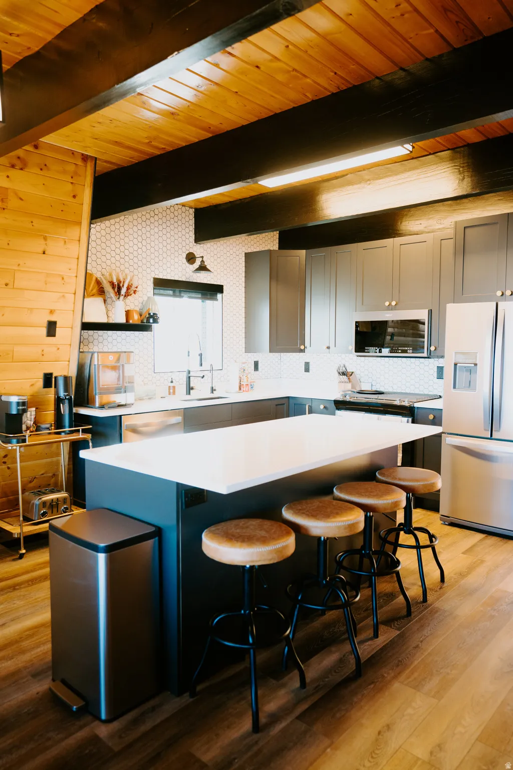 Kitchen featuring stainless steel appliances, a kitchen island, light wood finished floors, a breakfast bar area, and open shelves