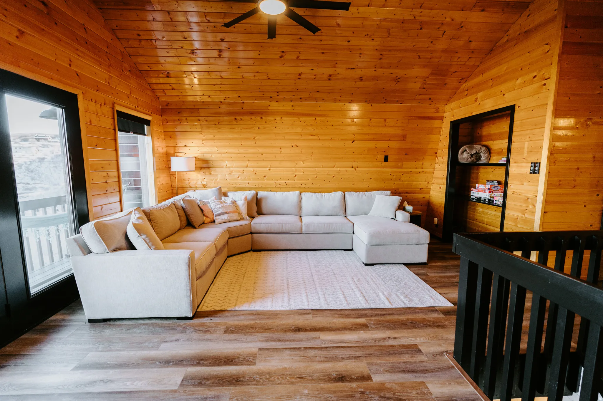 Living room featuring wooden walls, ceiling fan, wood finished floors, and a vaulted wood ceiling