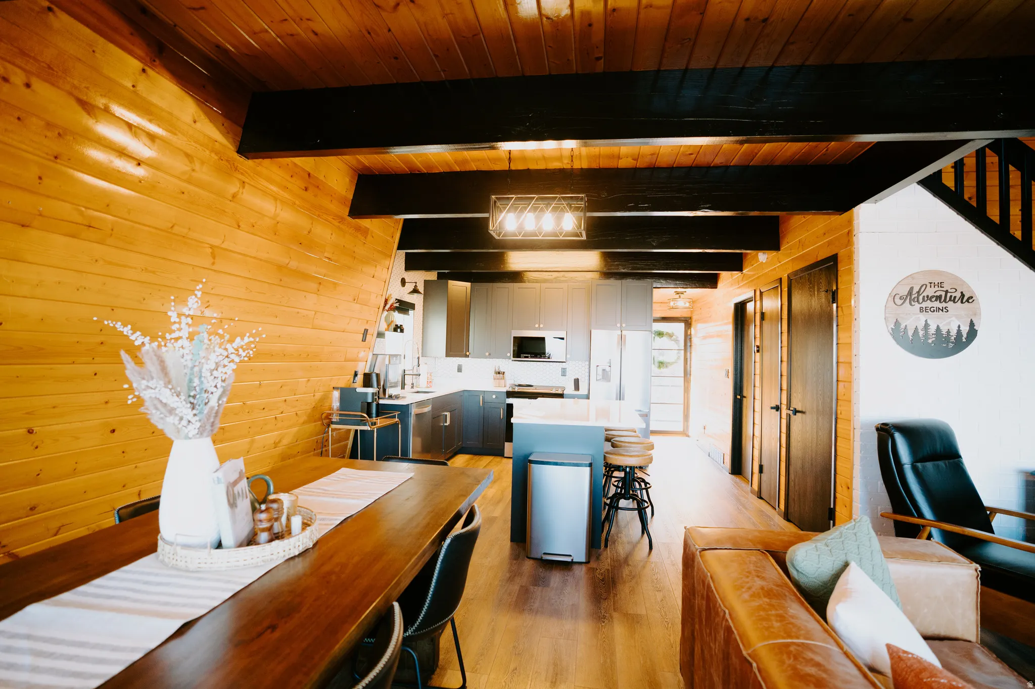 Dining space featuring wooden walls, light wood finished floors, and a wooden ceiling with exposed beams
