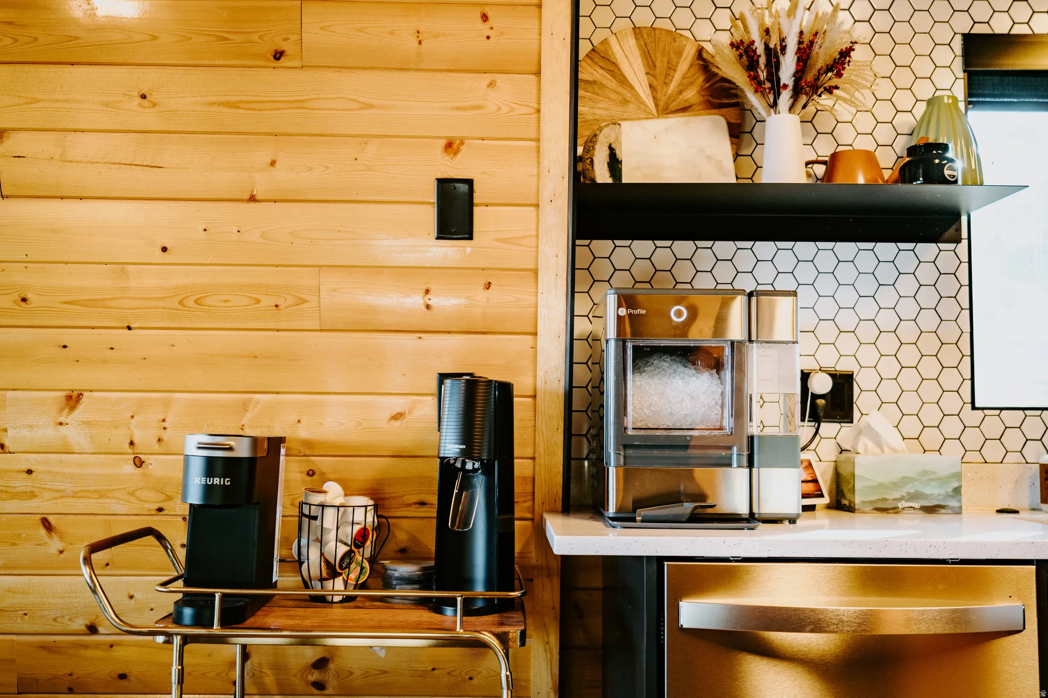 Kitchen featuring stainless steel dishwasher, open shelves, and light stone countertops