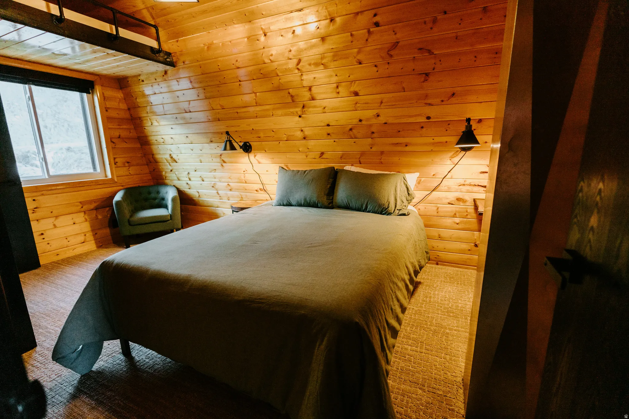 Carpeted bedroom featuring wood walls and a vaulted wooden ceiling