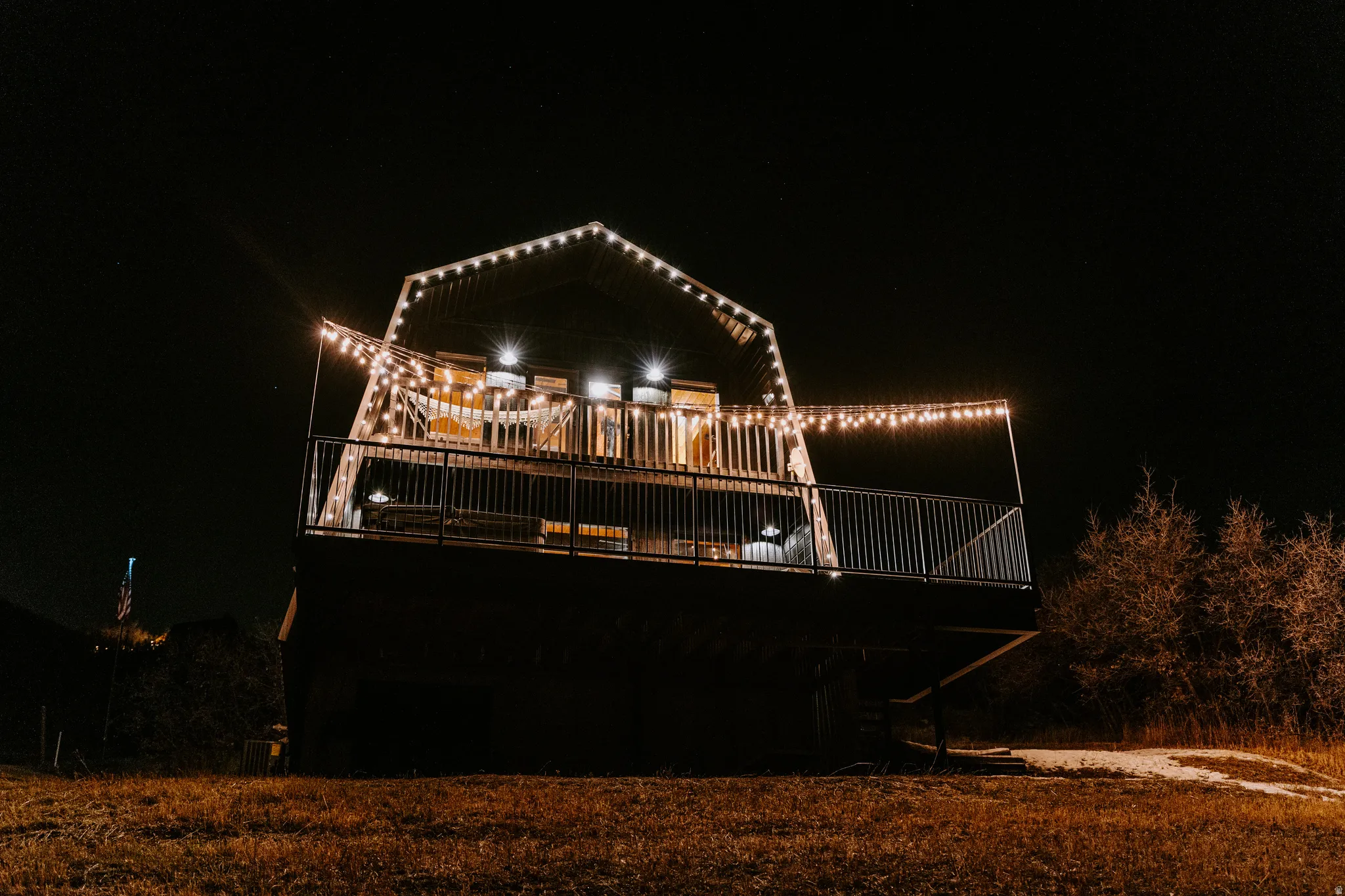 Back of house at night featuring a deck