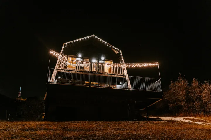 Back of house at night featuring a deck