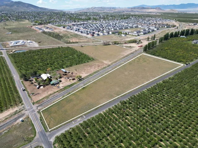 Aerial view of property and surrounding area with a mountainous background, extensive farmland, and rural landscape