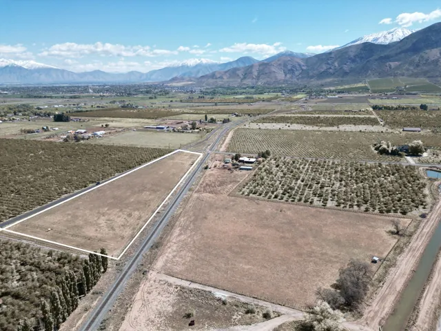 Aerial view of property and surrounding area with rural landscape, a mountainous background, and farmland