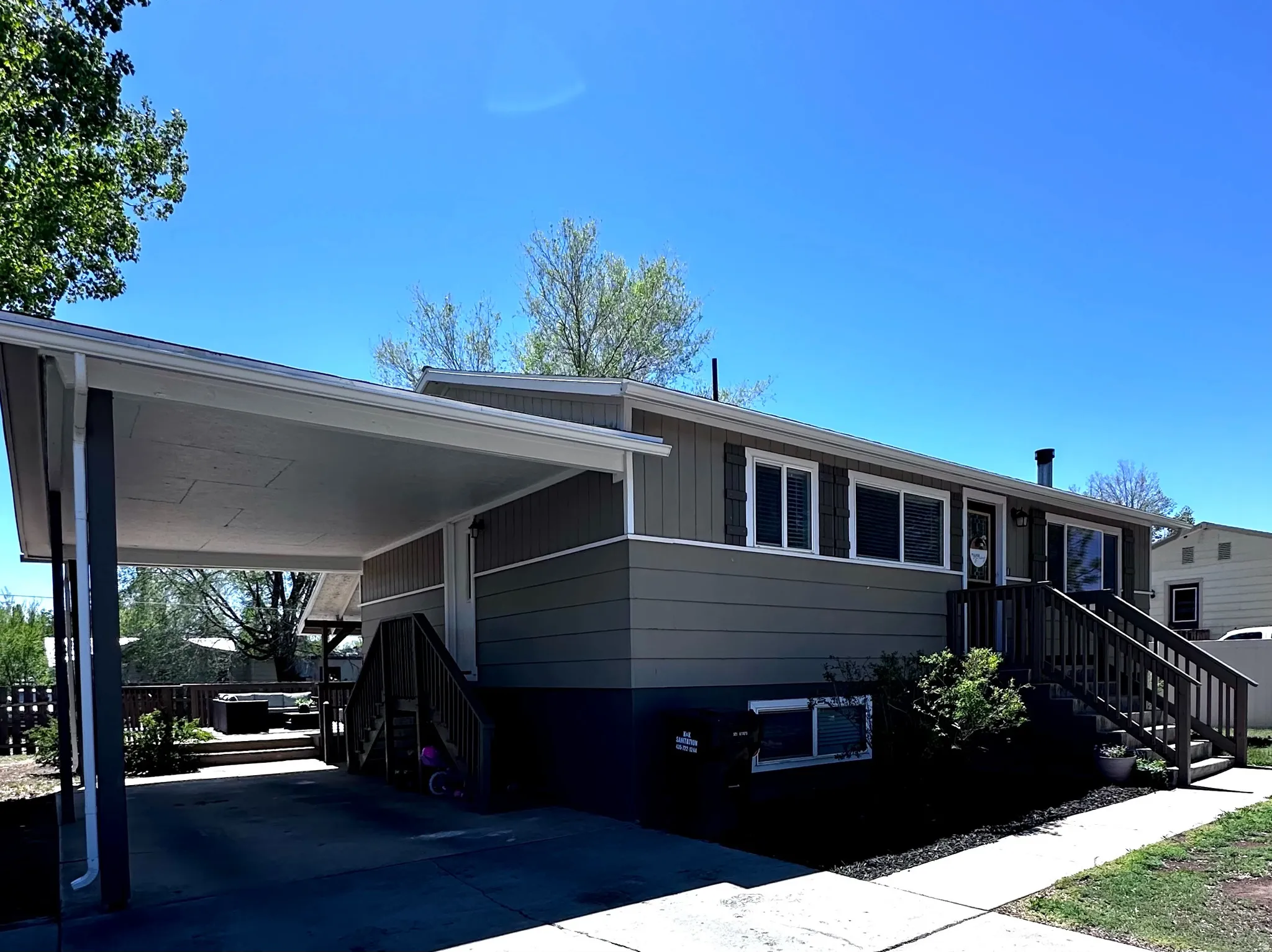View of front of property with an attached carport and concrete driveway