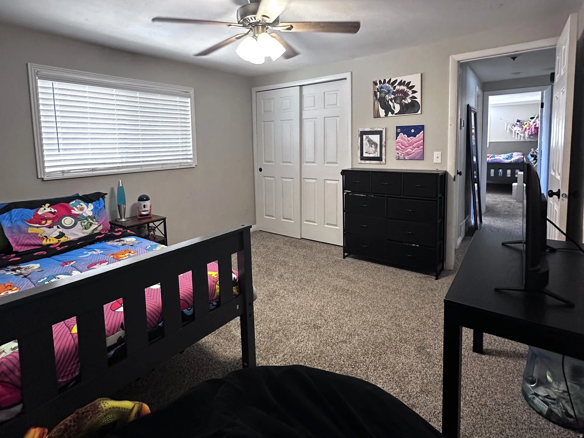Carpeted bedroom with a closet and a ceiling fan