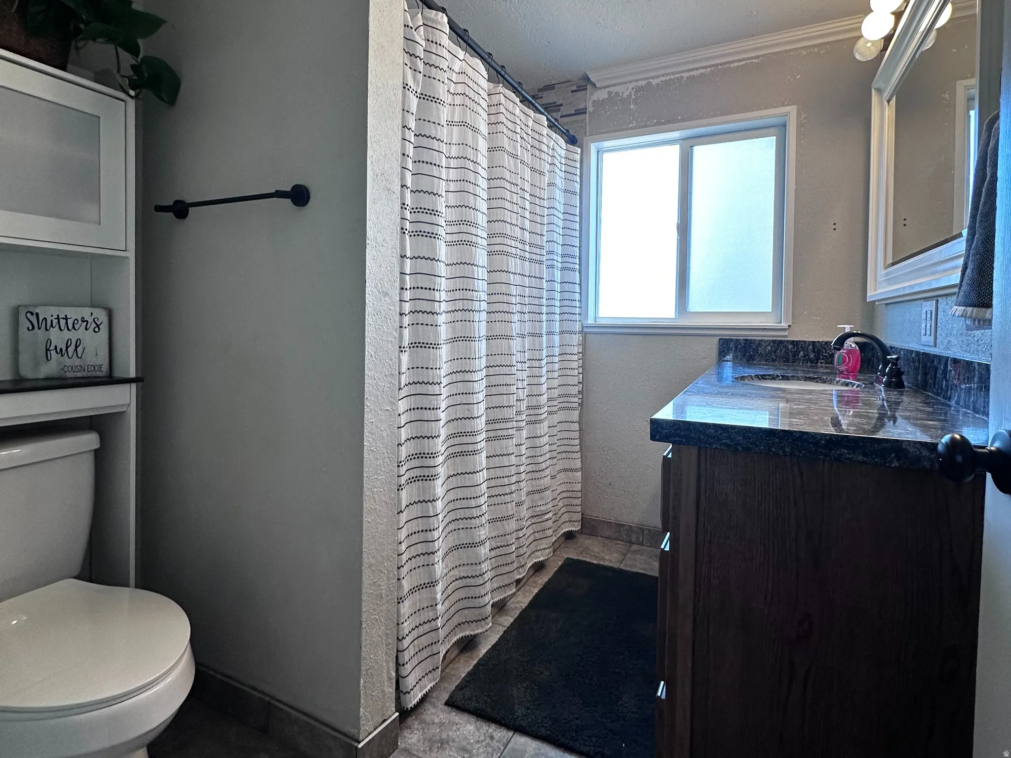 3/4 bath with granite countertop, and window
