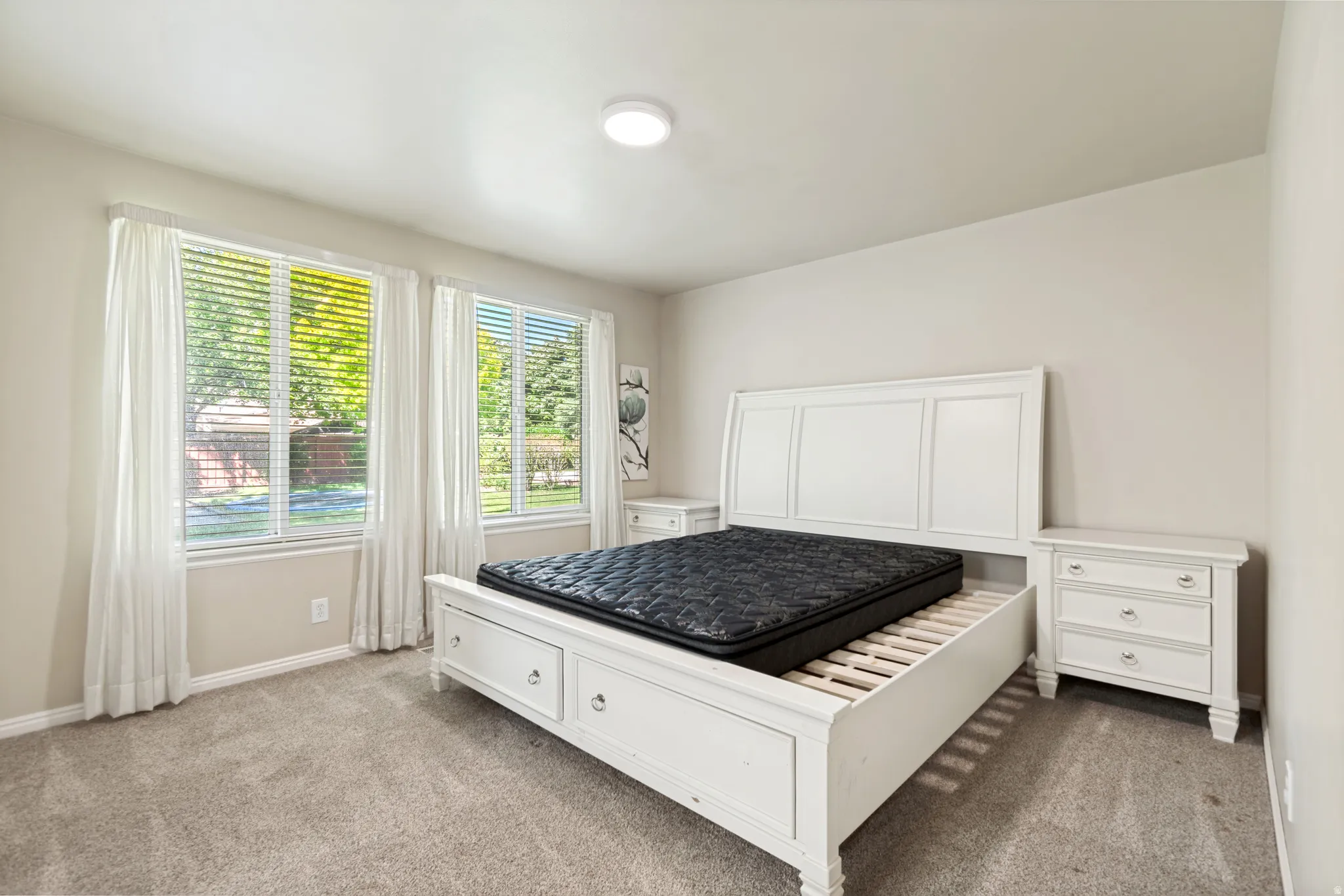 Neutral-toned walls complement the plush carpet flooring