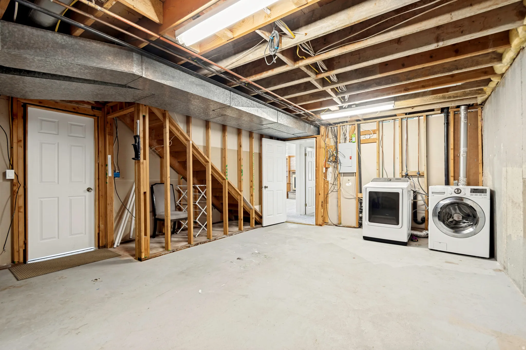 Unfinished basement offering exposed joists and framing, a concrete floor, and an exposed HVAC duct