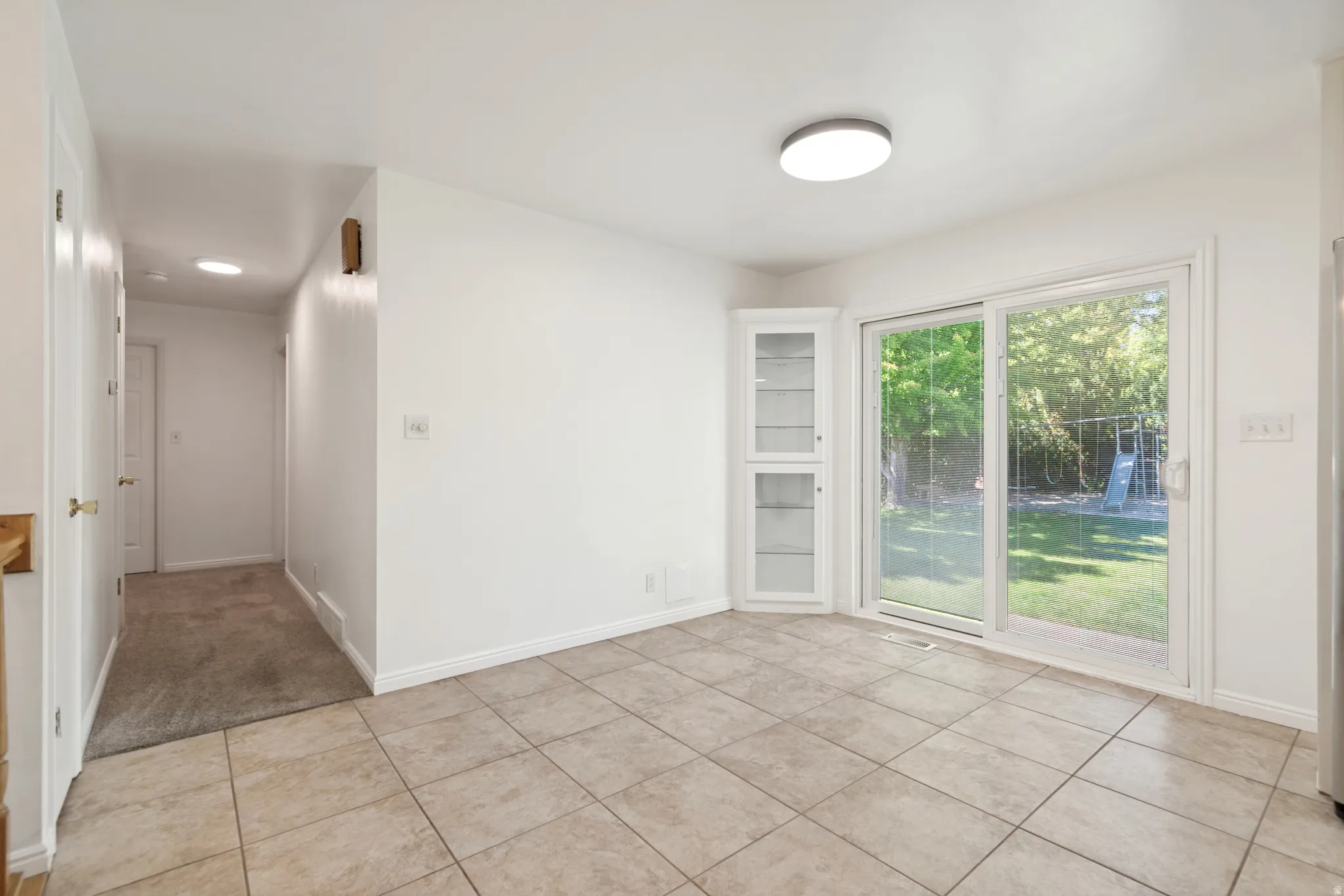 Tiled flooring with a sliding glass door providing natural light and exterior access