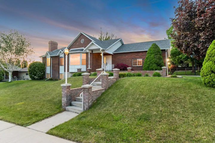 Ranch-style home with brick siding, a lawn, and roof with shingles