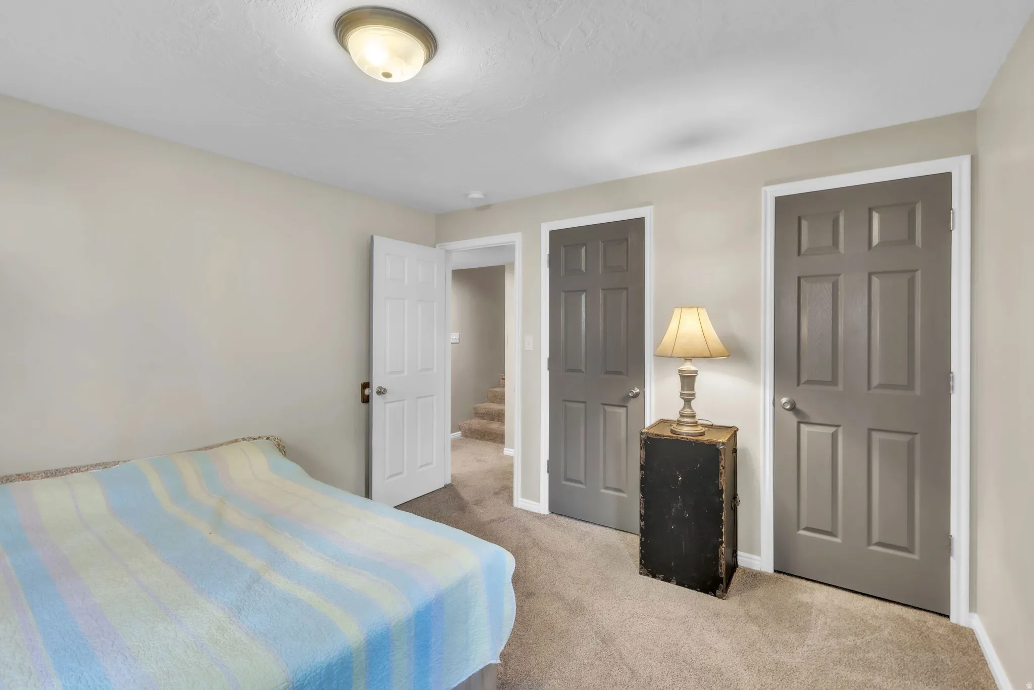 Bedroom featuring light carpet and baseboards