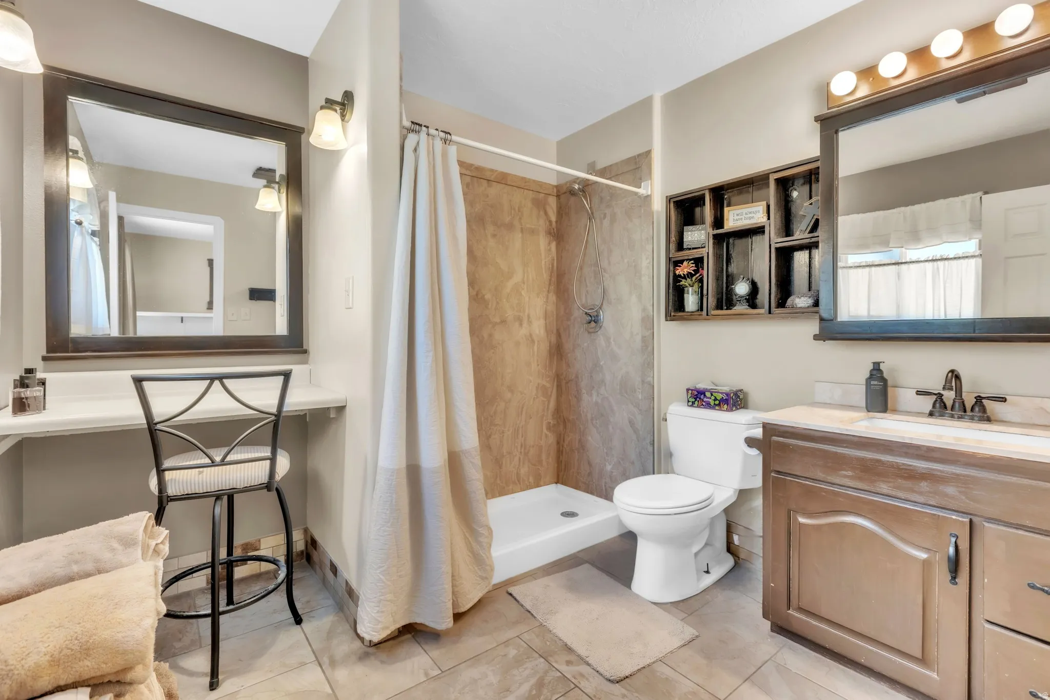 Bathroom featuring vanity, a shower stall, and light tile patterned flooring