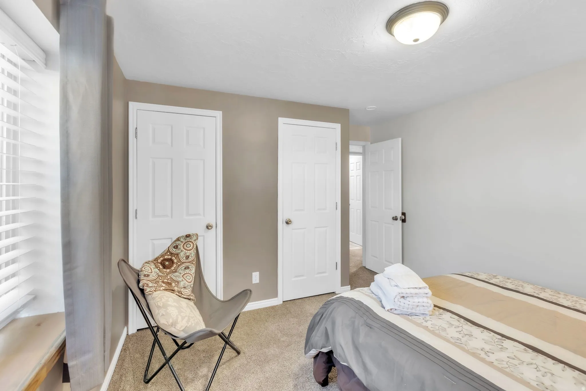 Bedroom with light colored carpet and baseboards