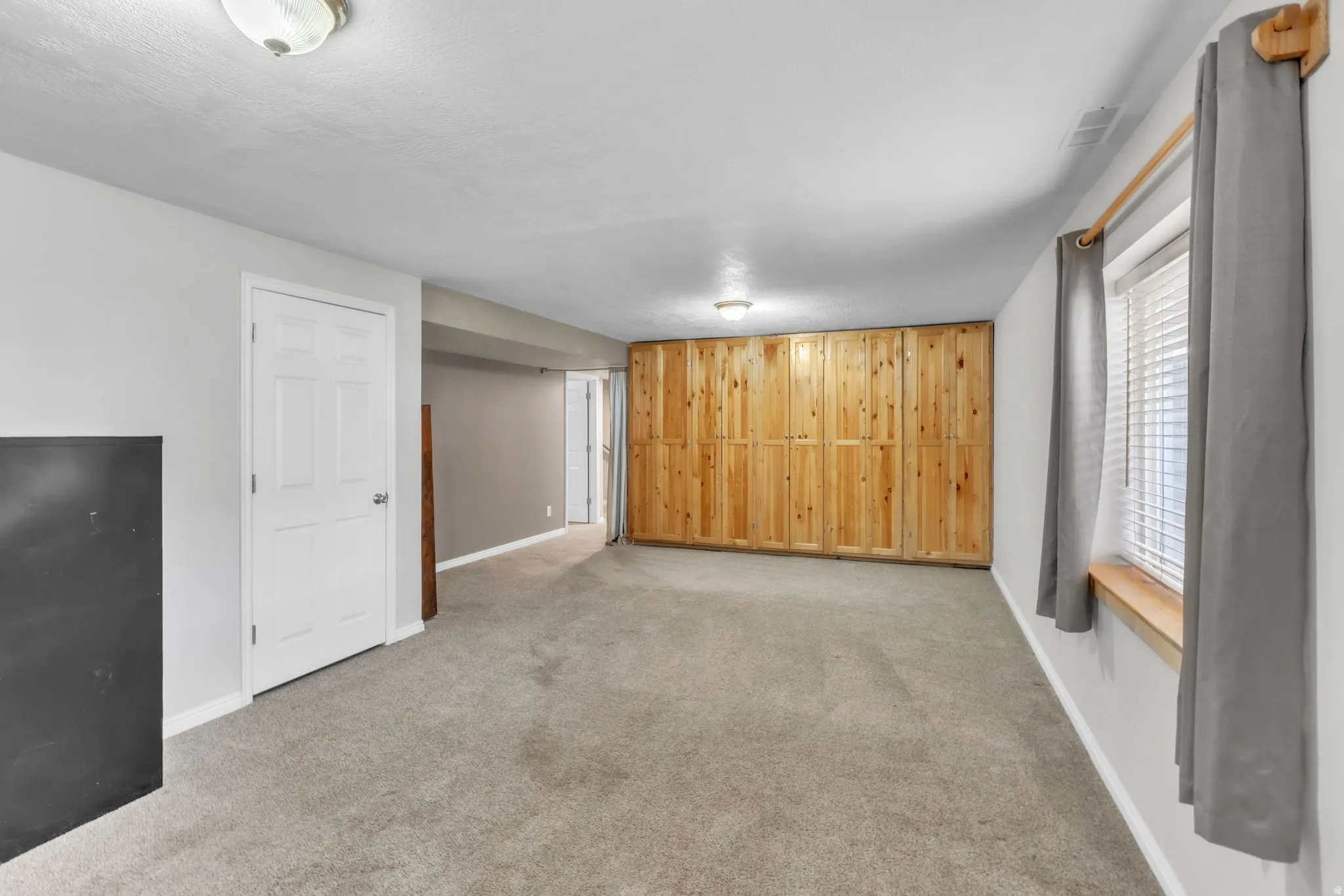 Unfurnished living room with baseboards and light colored carpet