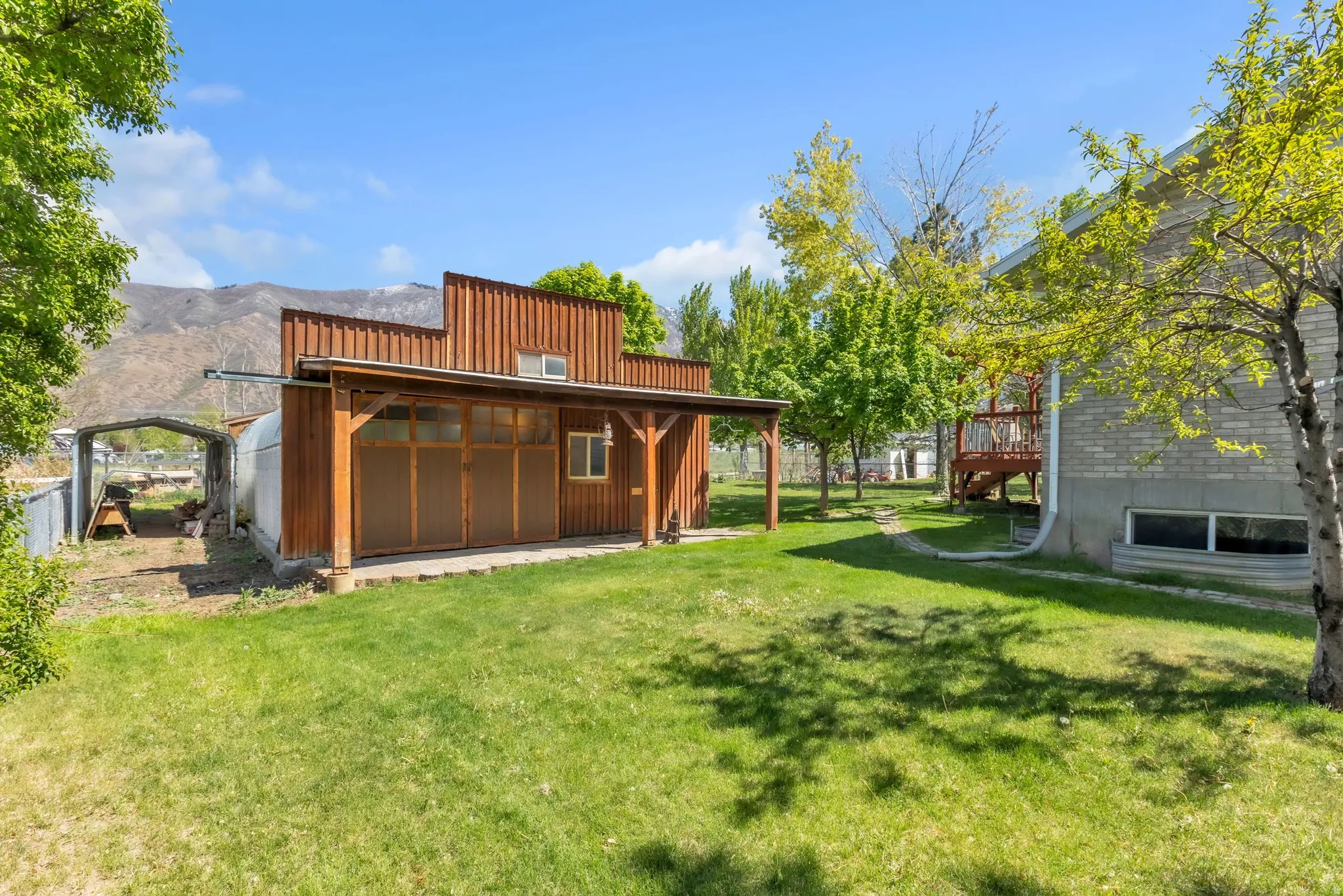 View of green lawn featuring a deck with mountain view