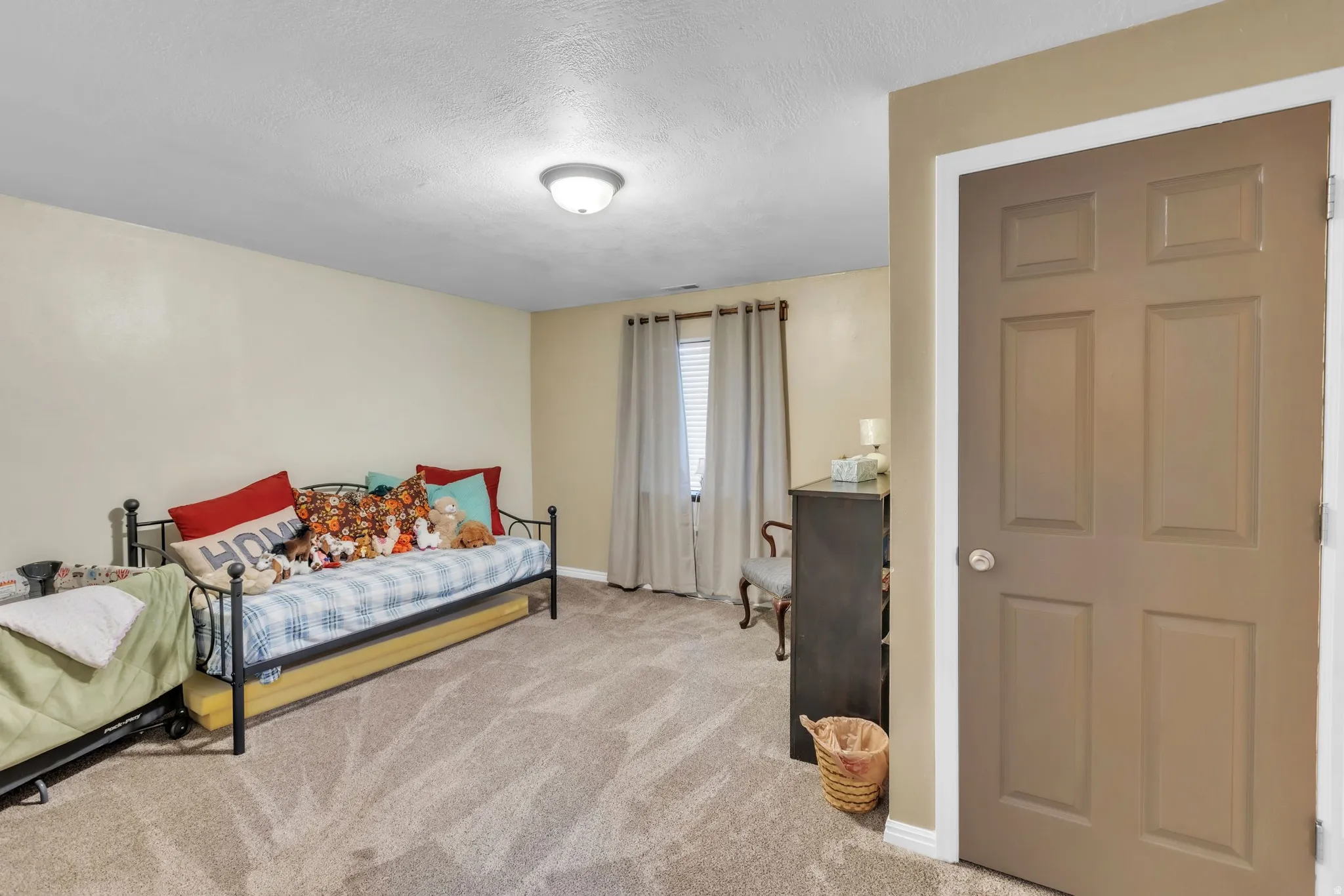 Bedroom featuring light carpet and a textured ceiling