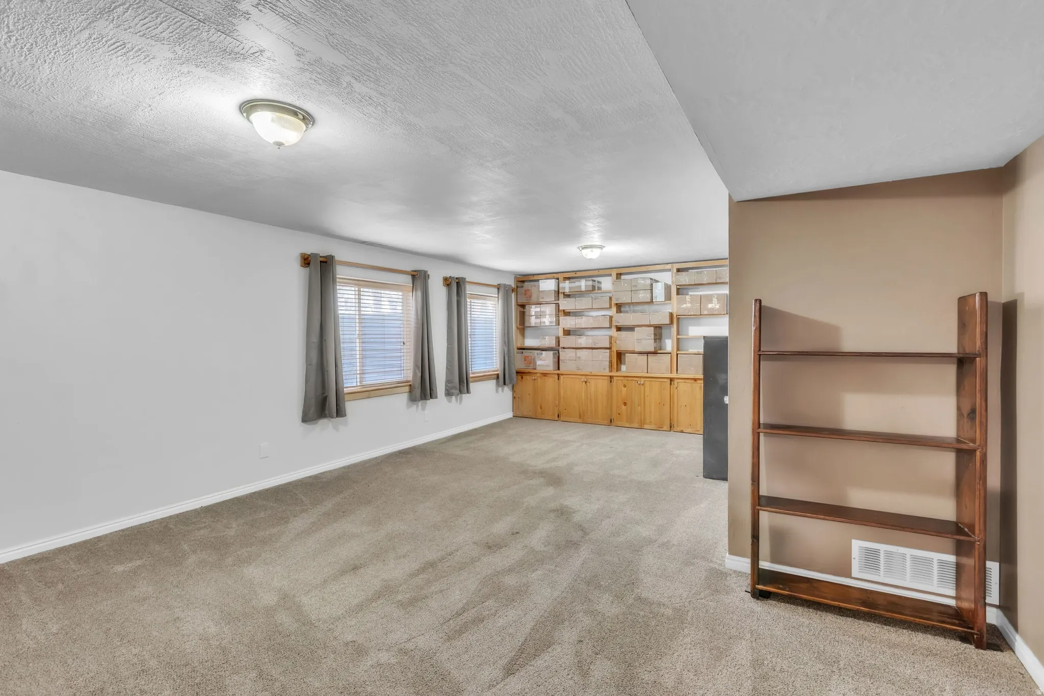 Spare room with light colored carpet and a textured ceiling