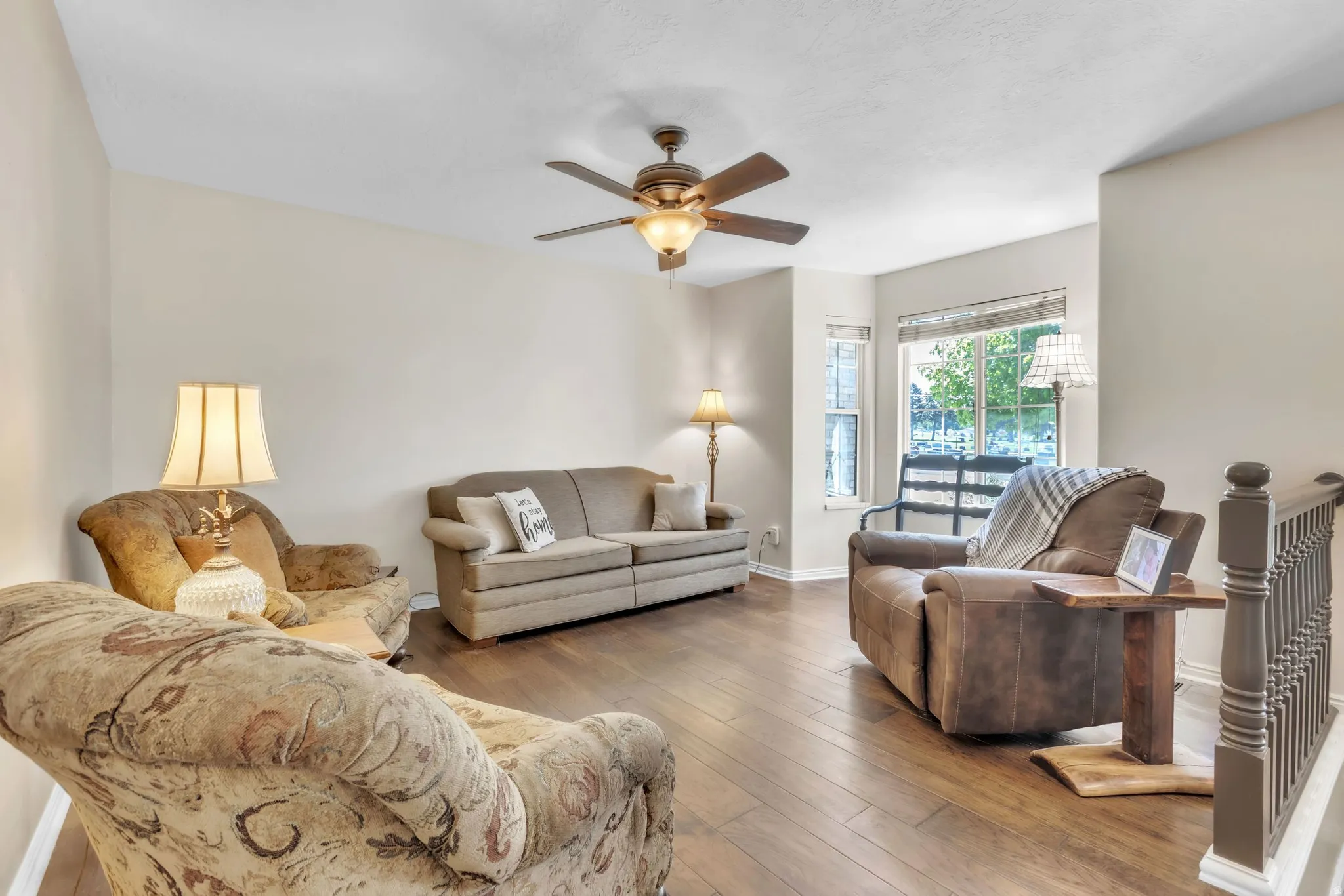 Living area with hardwood / wood-style floors and a ceiling fan