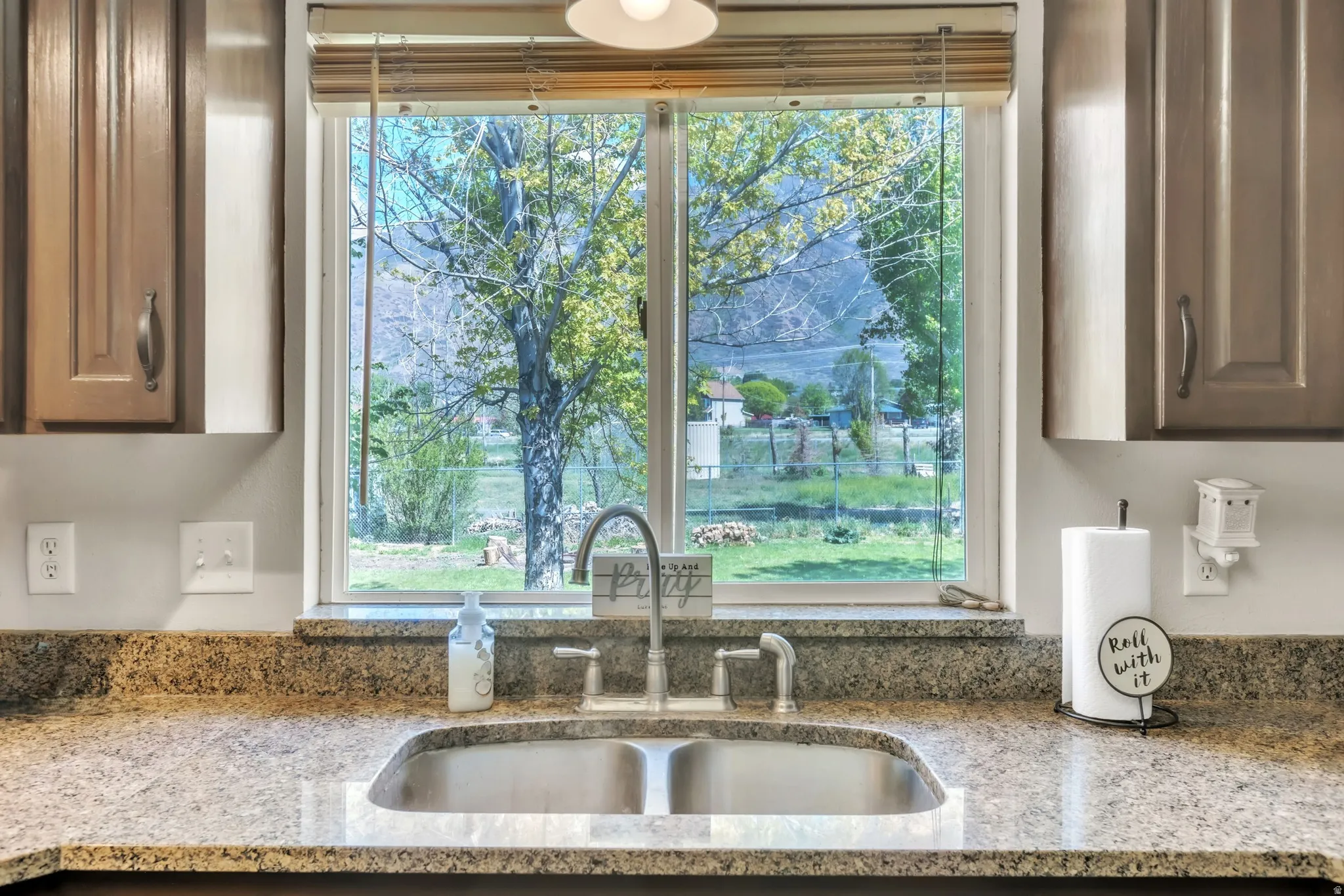 Kitchen view of light stone countertops and a sink
