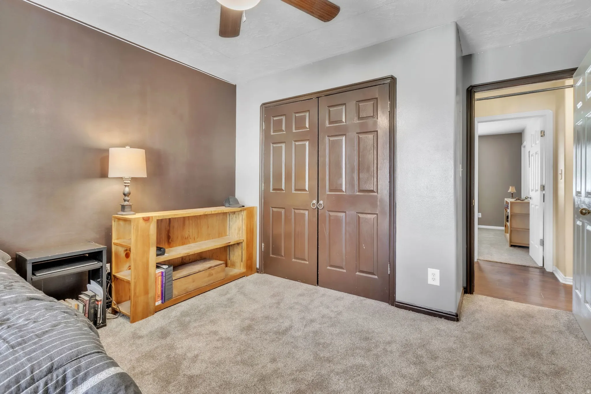 Carpeted bedroom featuring a closet and ceiling fan