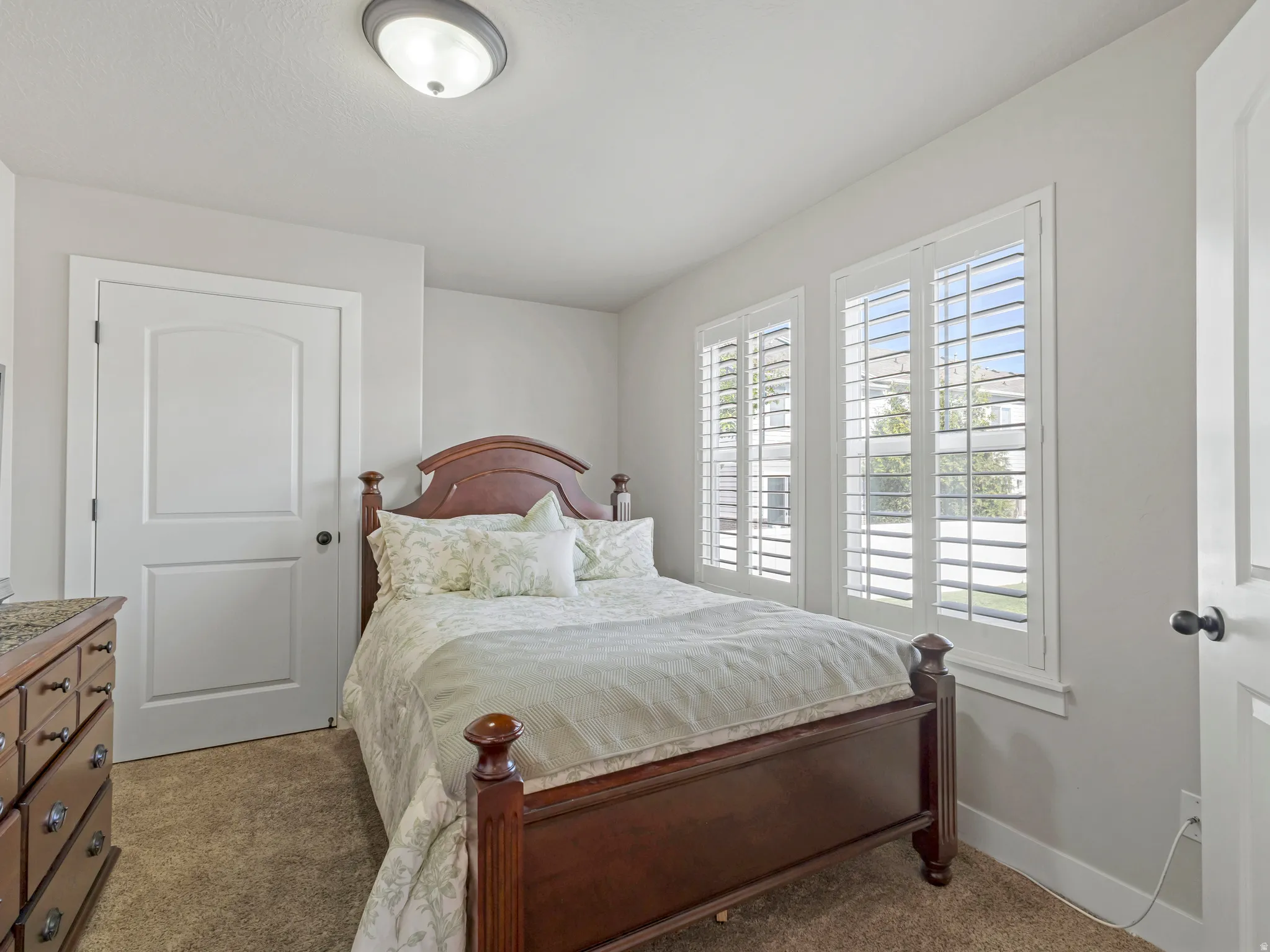 Bedroom with light colored carpet and baseboards