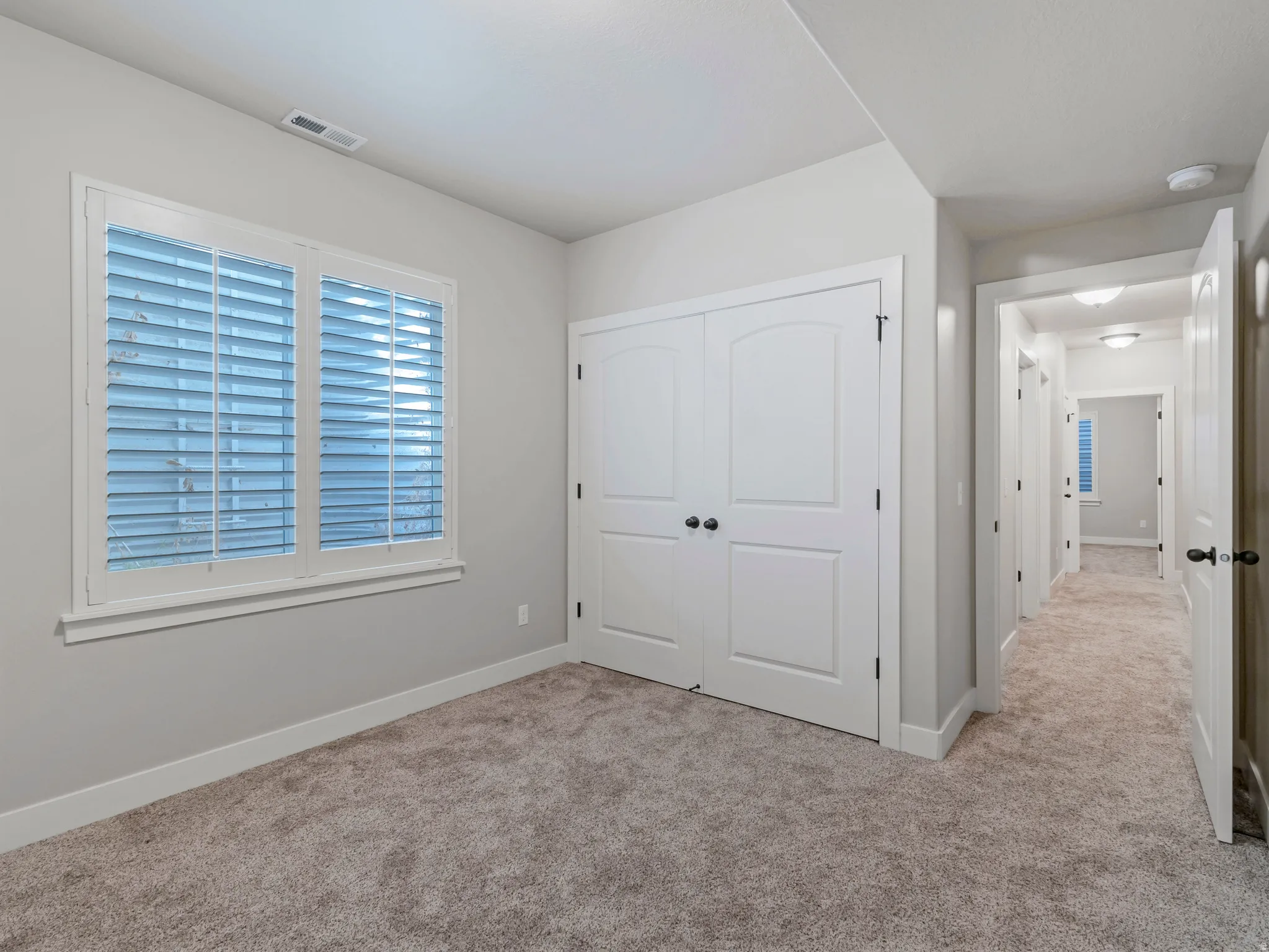 Unfurnished bedroom with a closet and light colored carpet