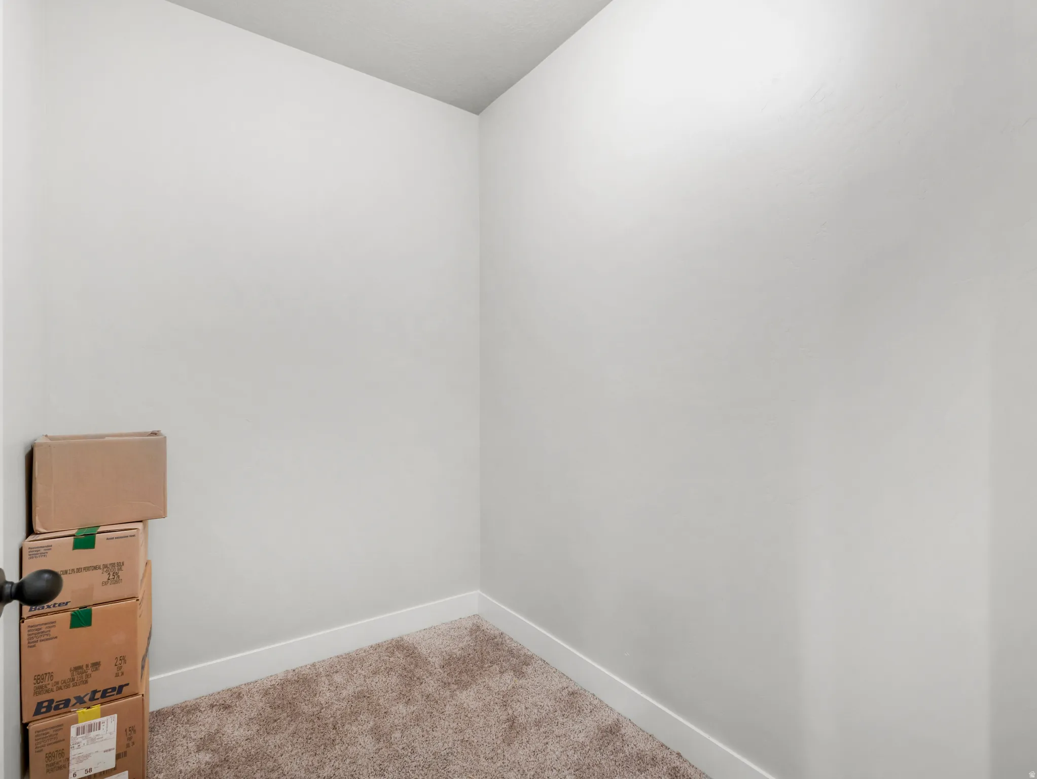 Carpeted spare room featuring baseboards