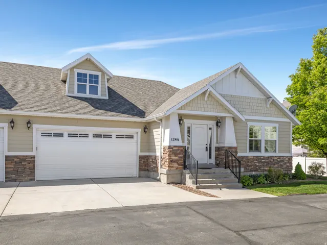 Craftsman house with stone siding, roof with shingles, an attached garage, and concrete driveway