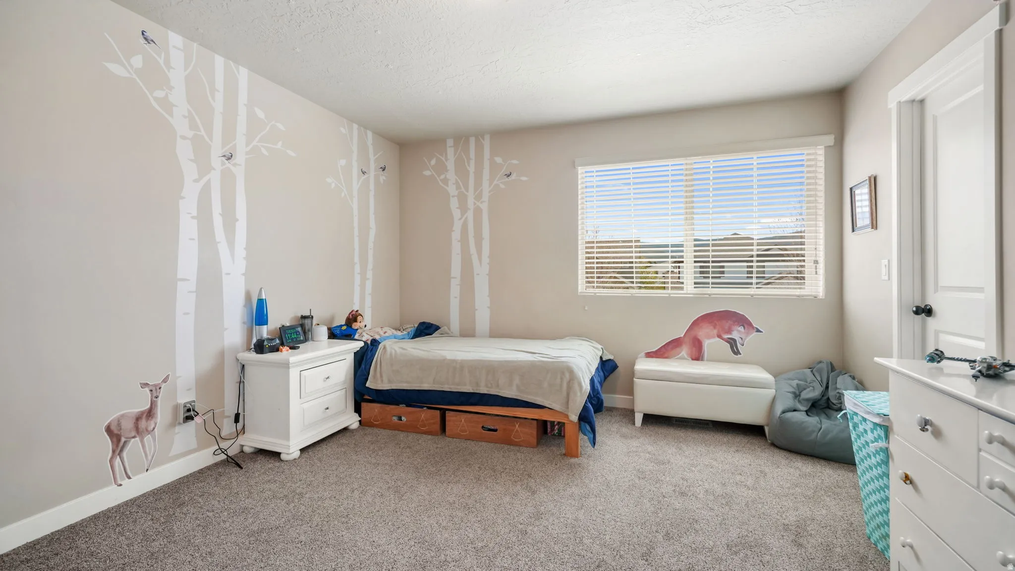 Carpeted bedroom with a textured ceiling and baseboards