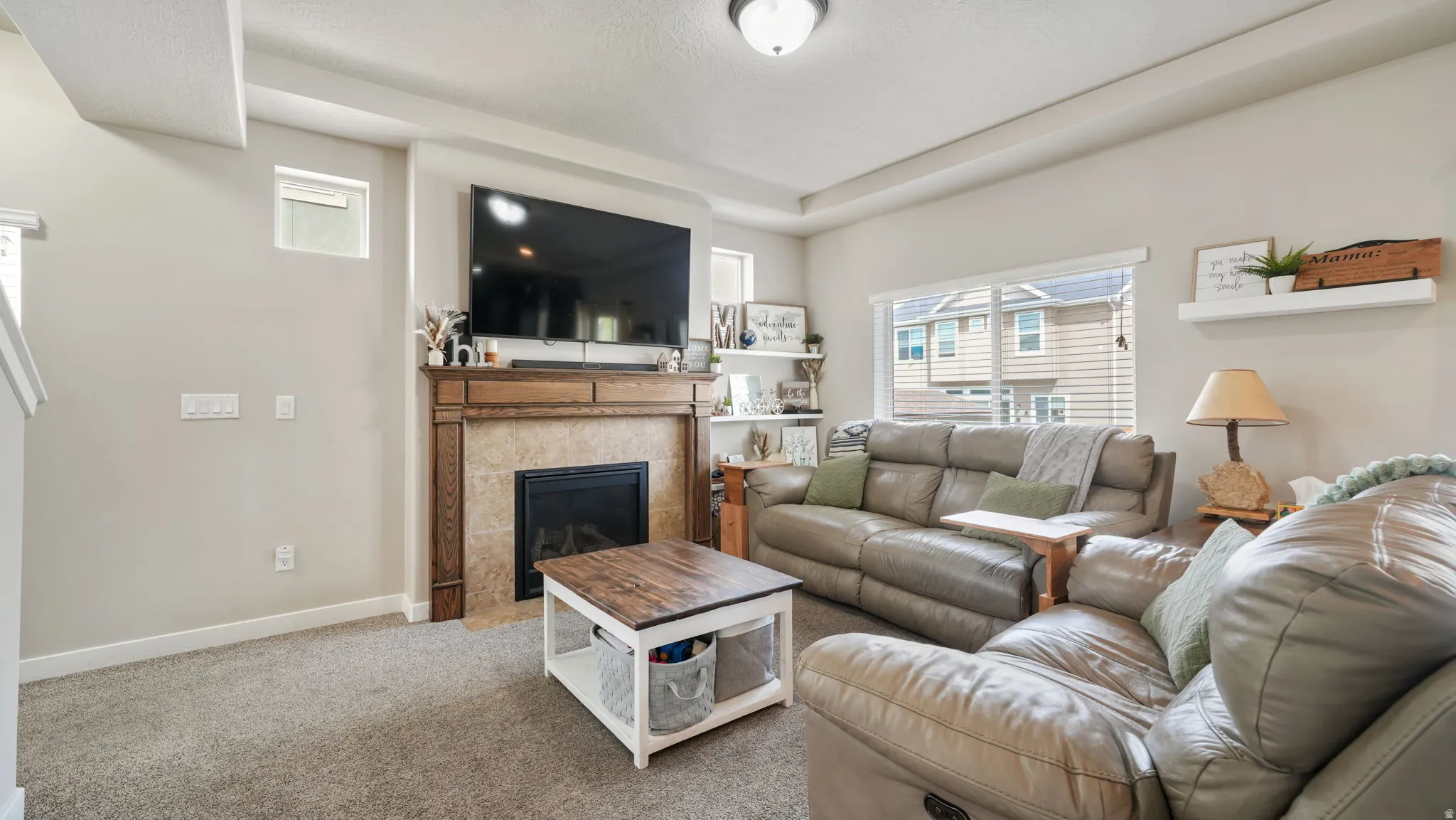 Living room featuring a tile fireplace and carpet flooring