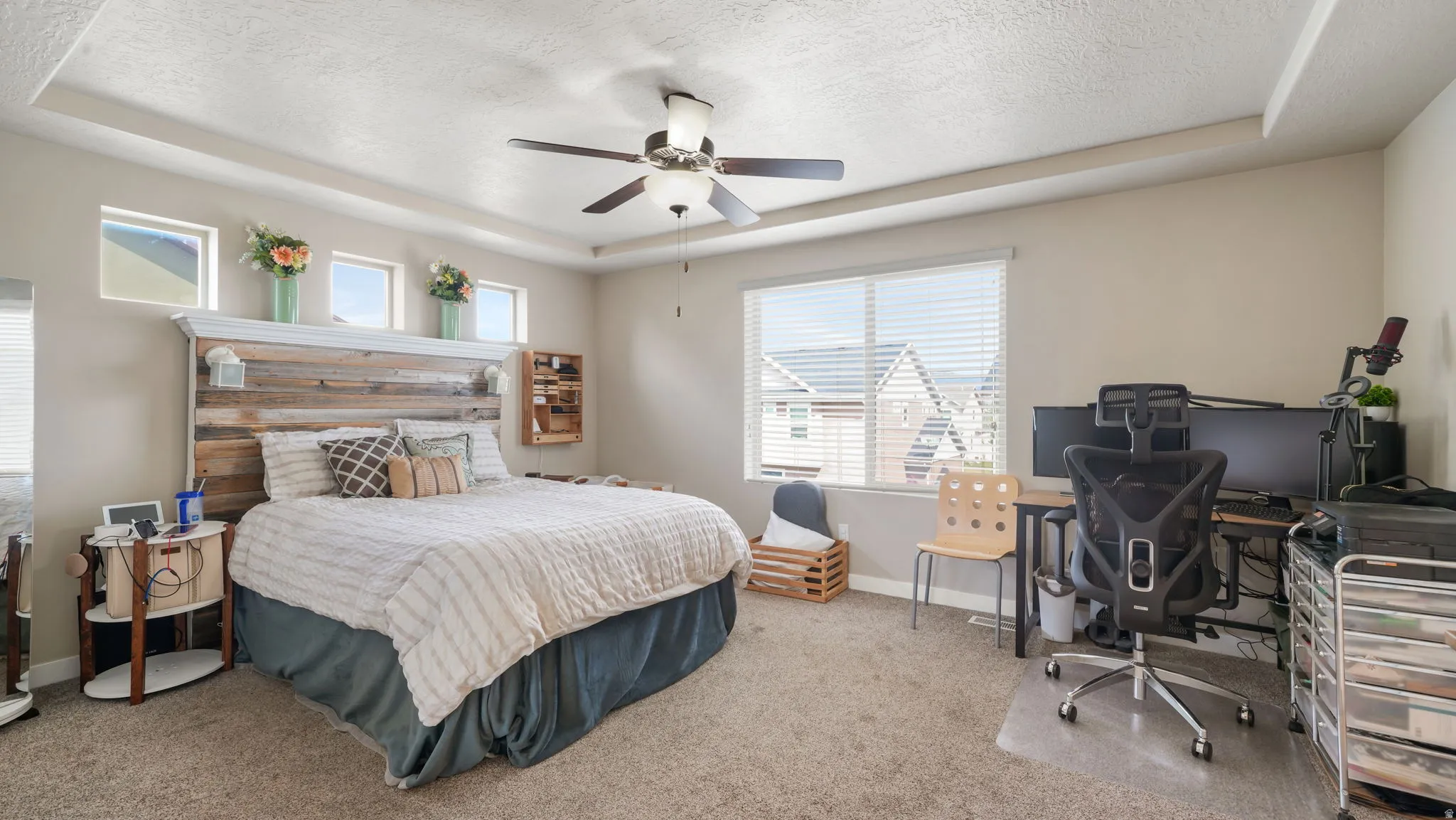 Master Bedroom Carpeted bedroom featuring a raised ceiling, a ceiling fan, an office area, and a textured ceiling