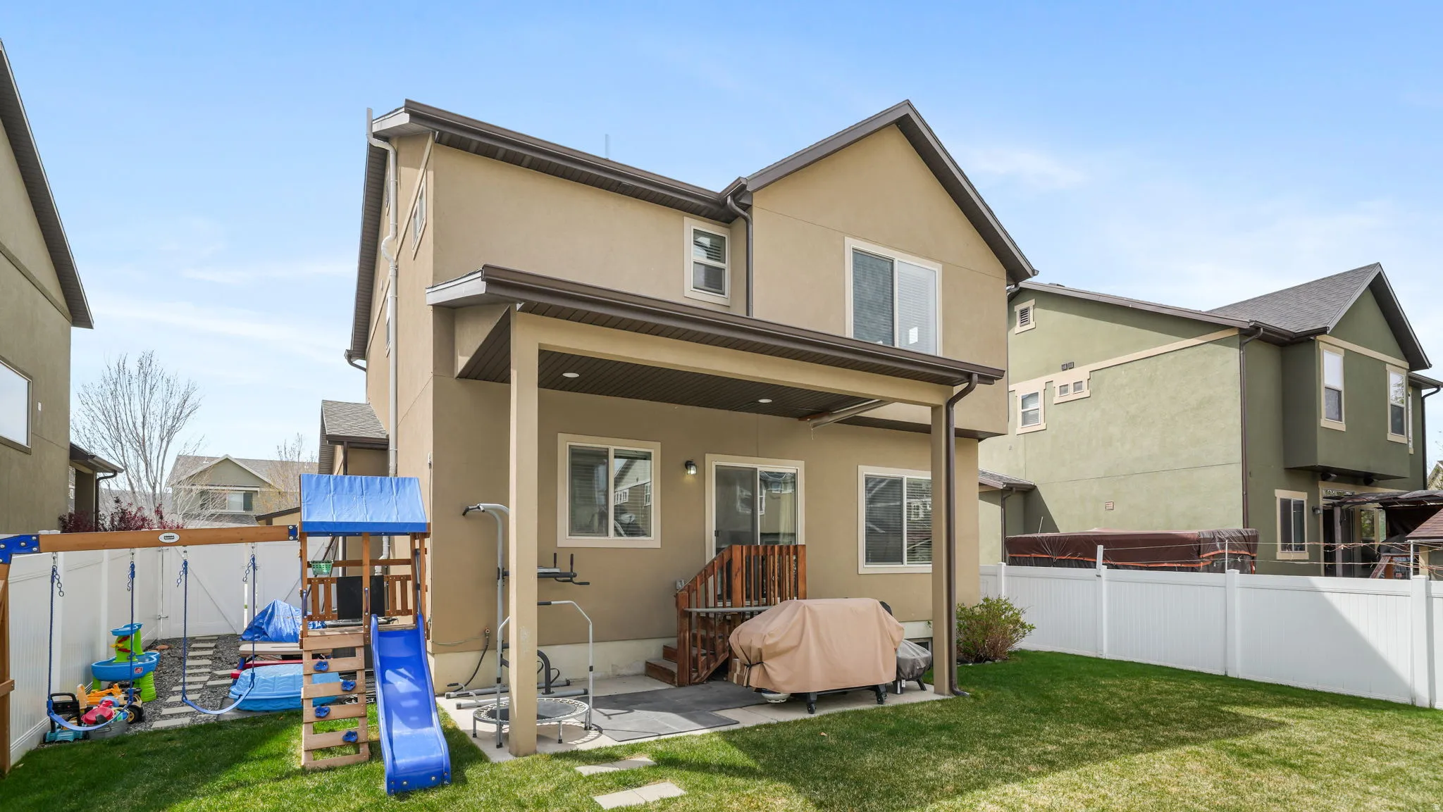 Back of house featuring stucco siding, a fenced backyard, and a patio