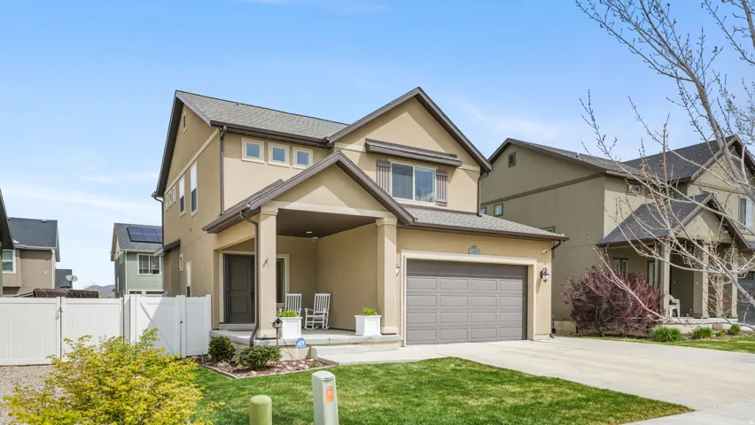 View of front of home with a gate, stucco siding, concrete driveway, covered porch, and a garage