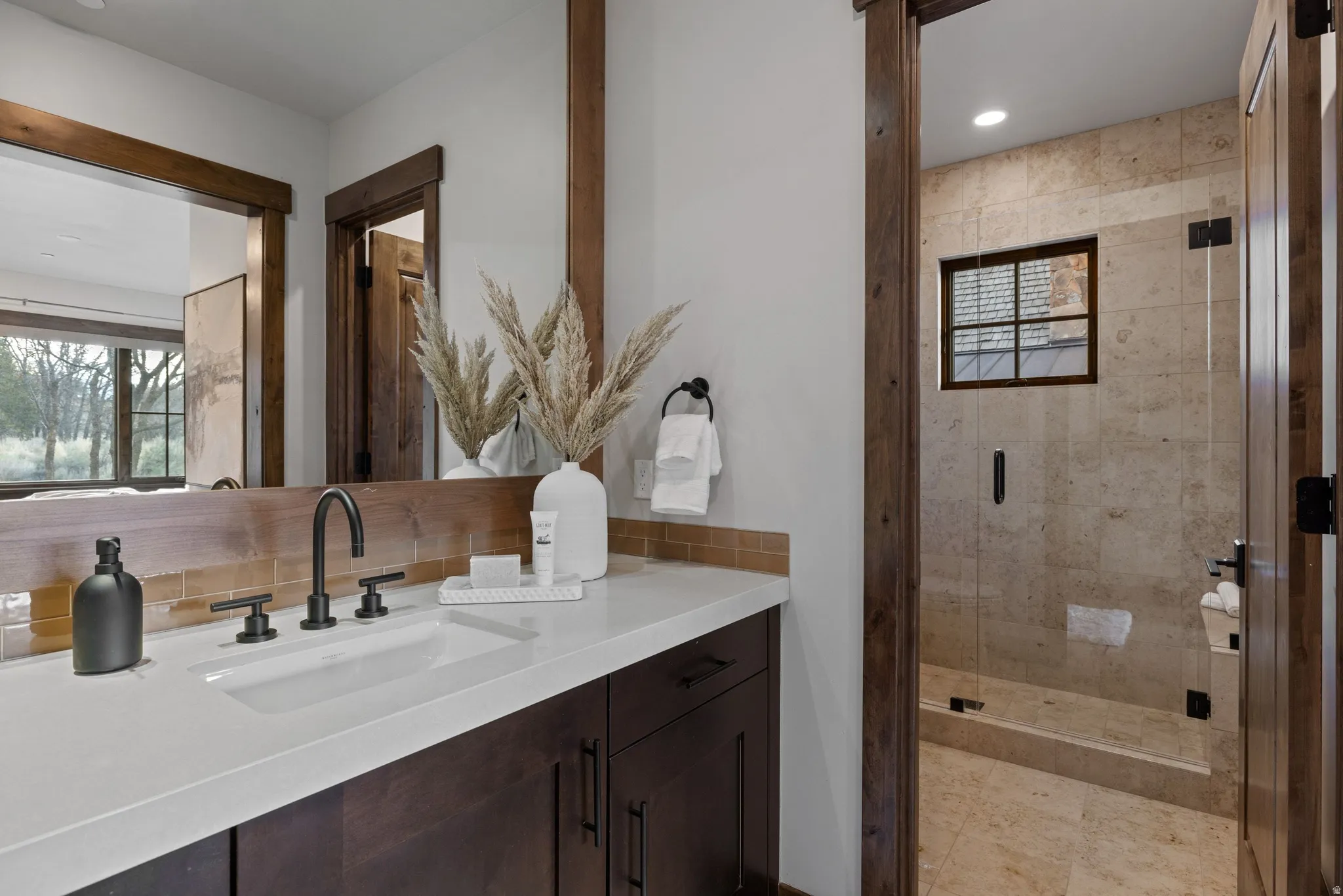 Full bath featuring vanity, a shower stall, tasteful backsplash, and recessed lighting