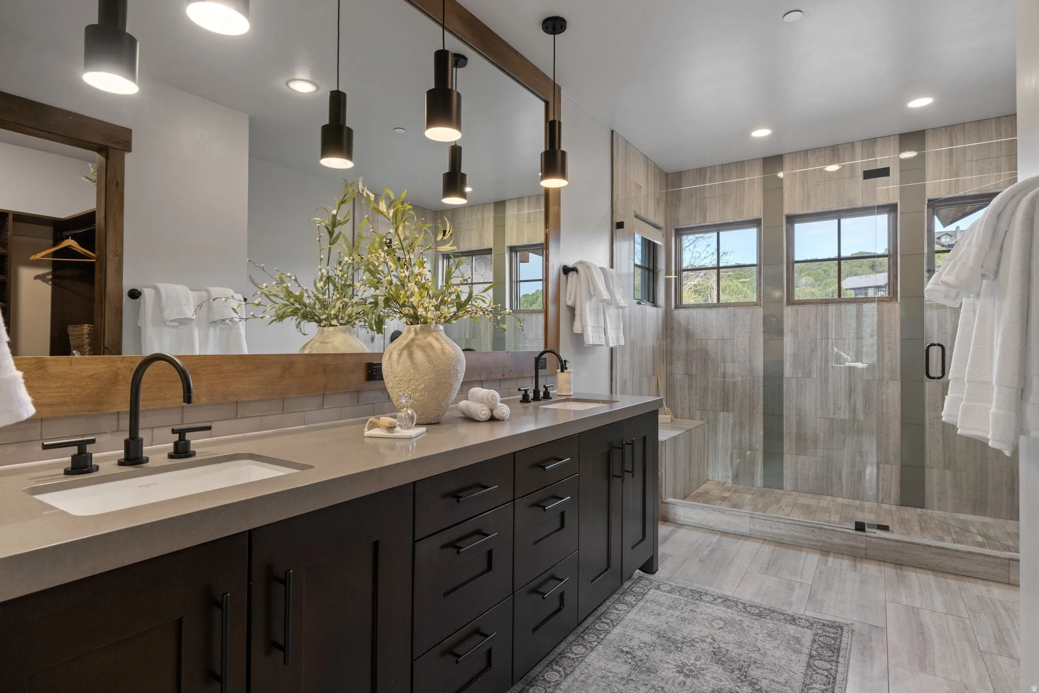 Full bath with double vanity, a shower stall, and recessed lighting