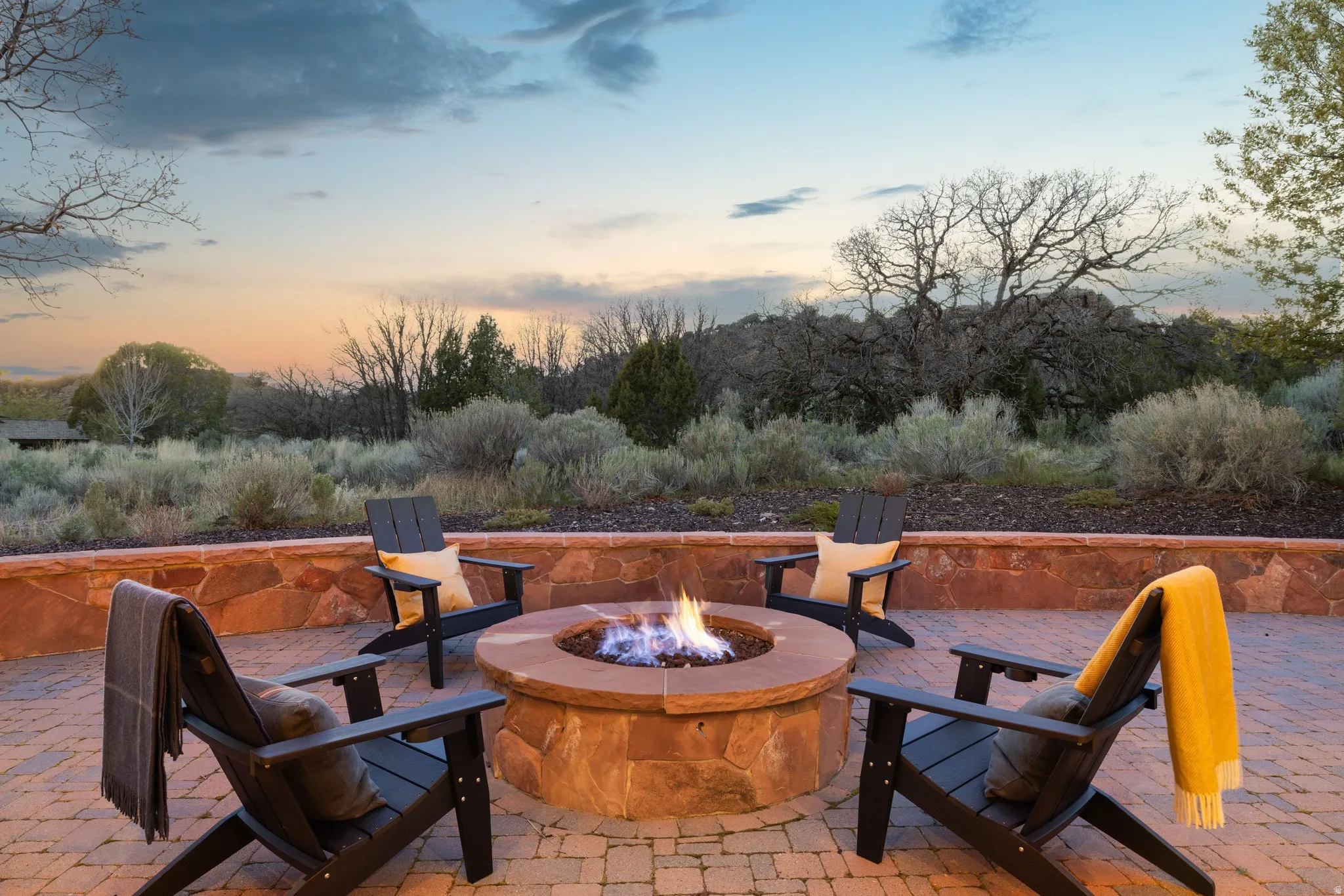 Patio terrace at dusk with an outdoor fire pit and a patio