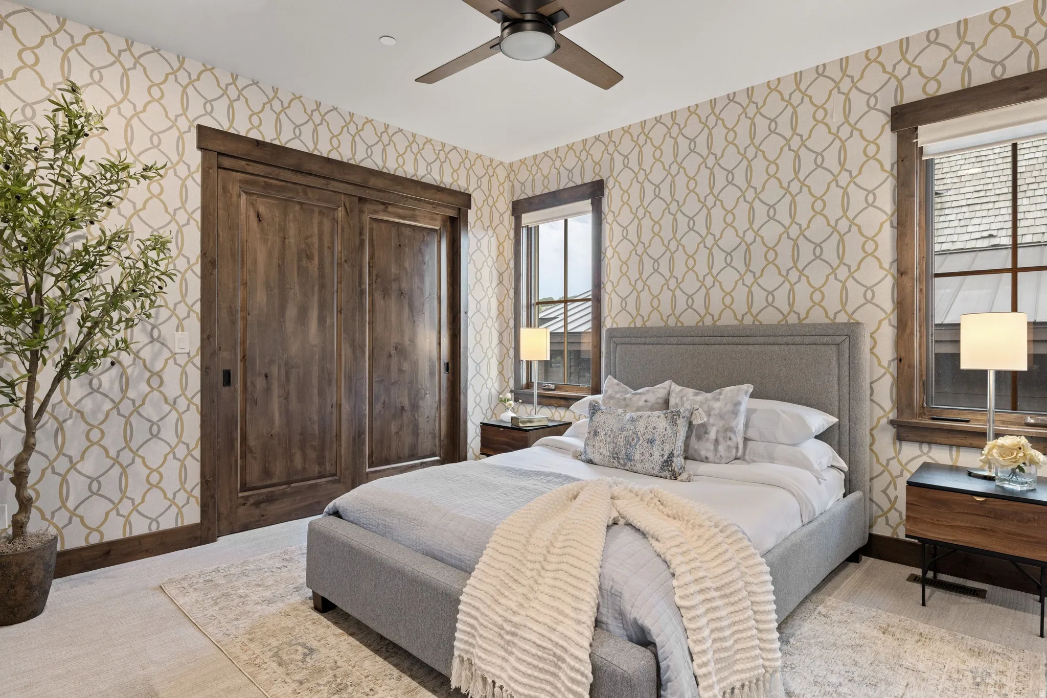Bedroom featuring wallpapered walls and a ceiling fan
