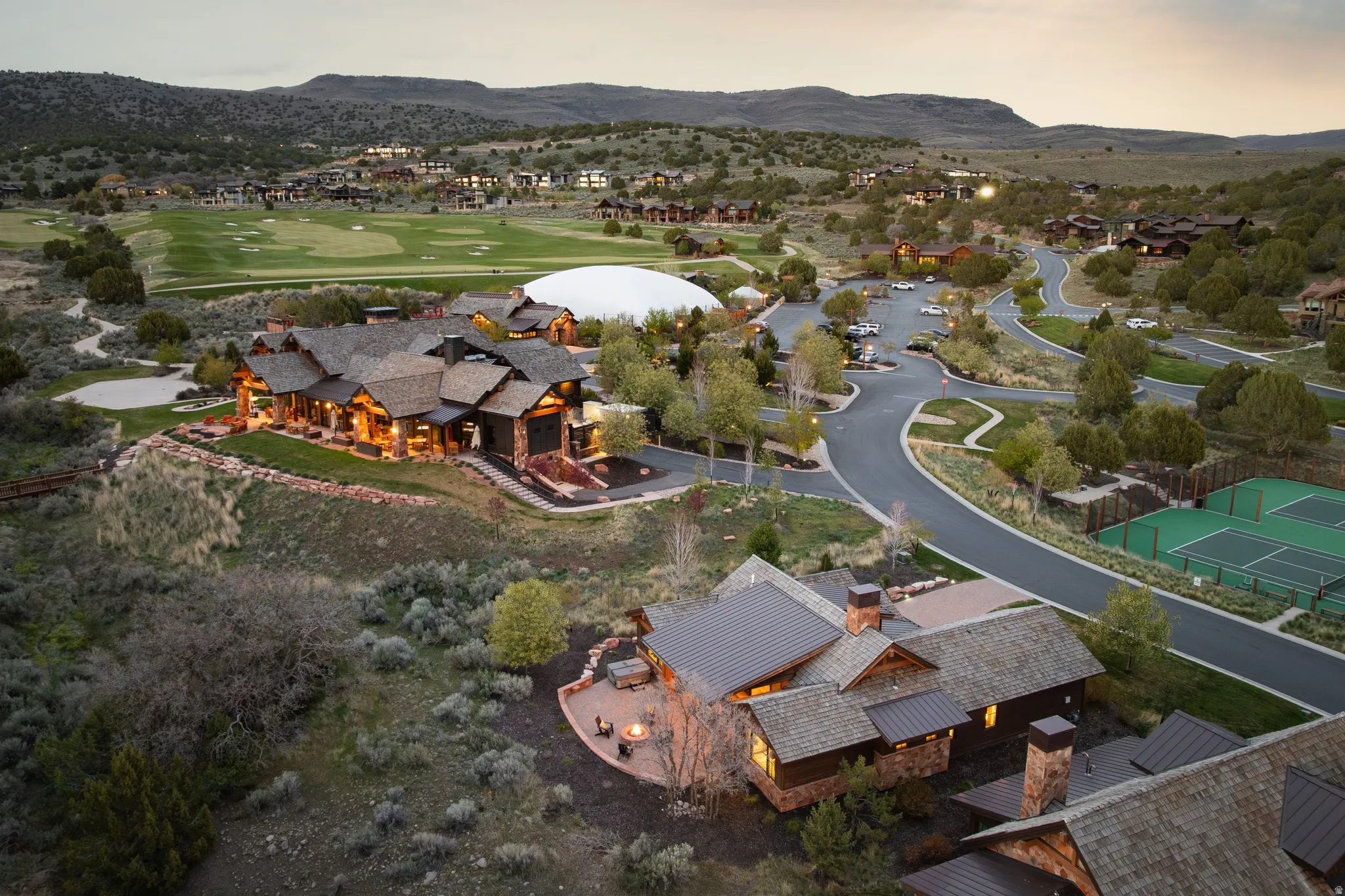 Aerial view at dusk of a mountain view, golf course view, and a residential view