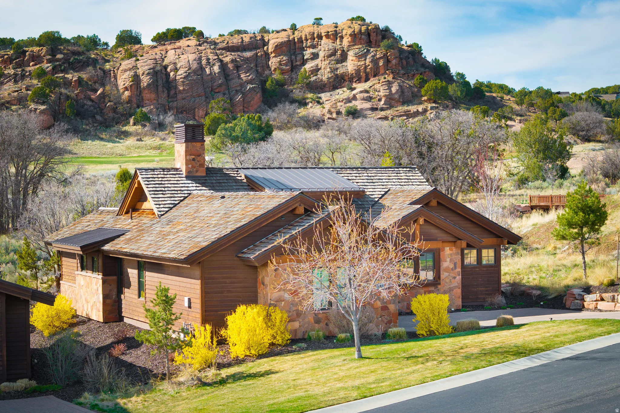 View of home's exterior featuring a chimney, a lawn, and stone siding