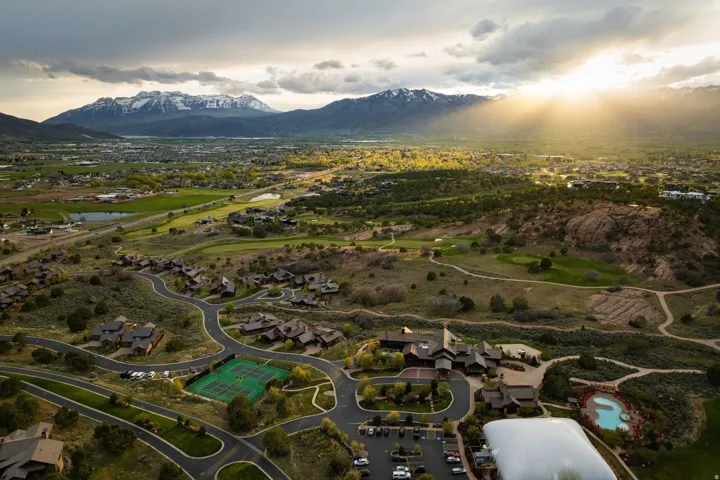 Aerial perspective of suburban area featuring a water and mountain view and a local golf course