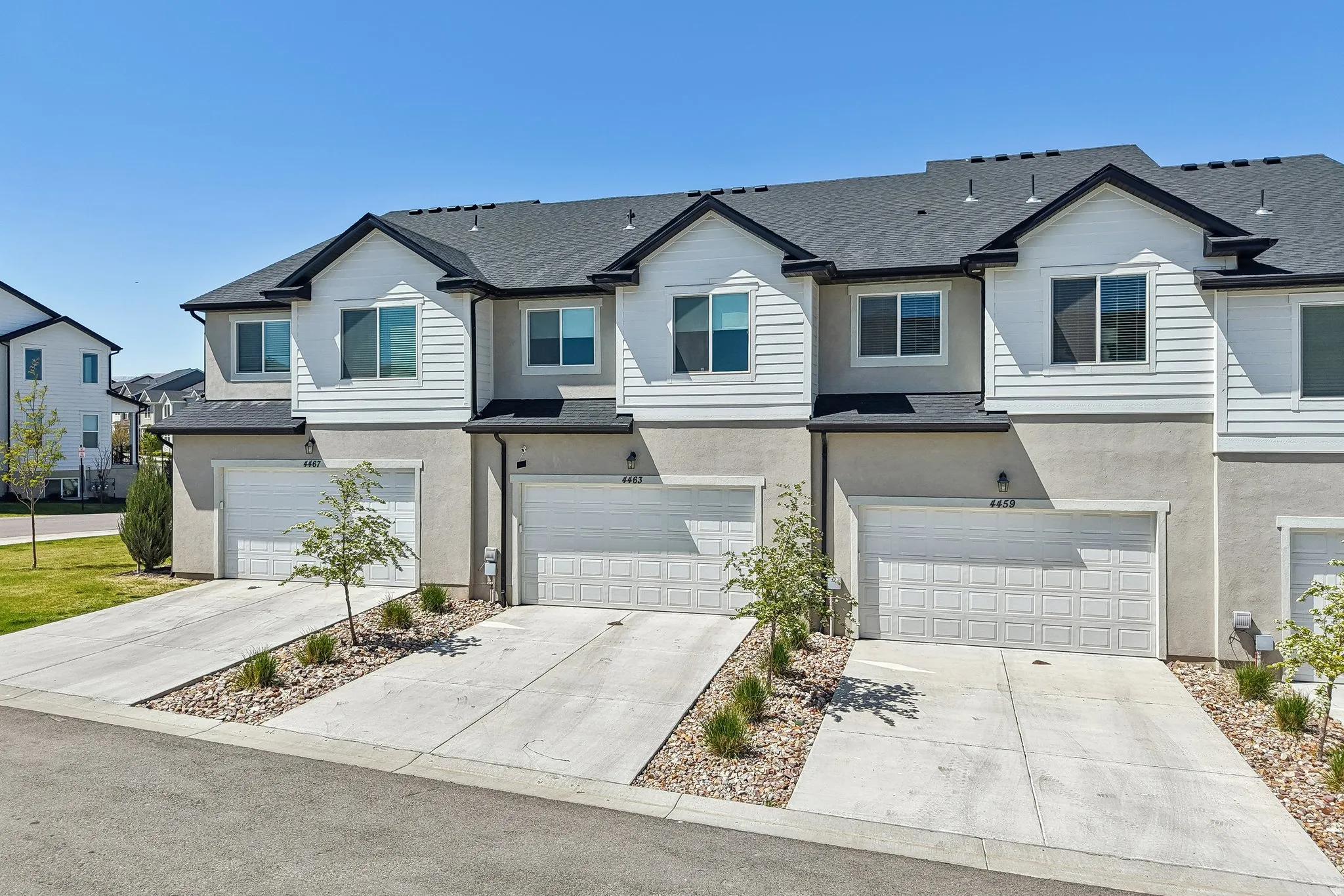 Traditional-style home with a residential view, an attached garage, concrete driveway, and stucco siding