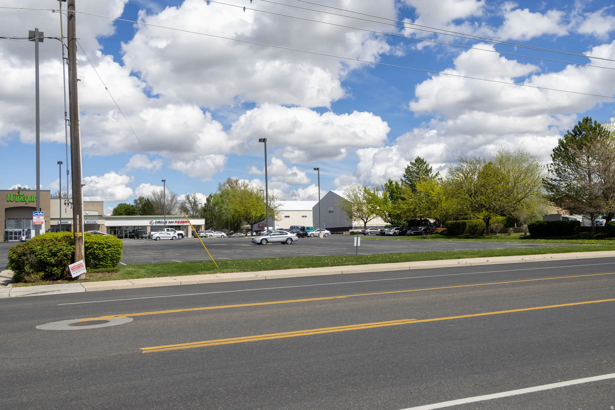 View of asphalt street featuring curbs and sidewalks