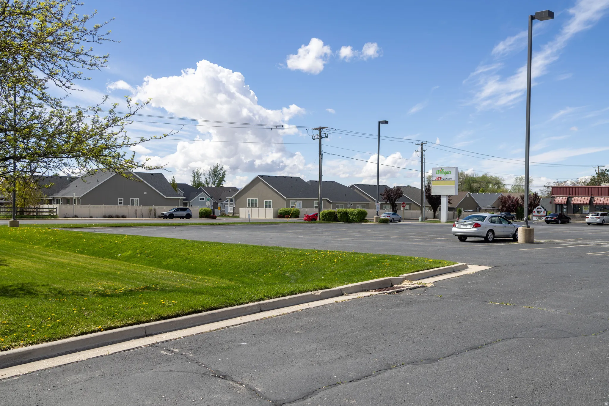 View of asphalt street featuring a residential view and curbs
